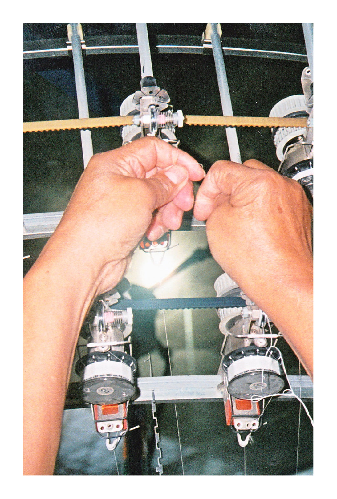 Person operating a machine with multiple spools of thread.