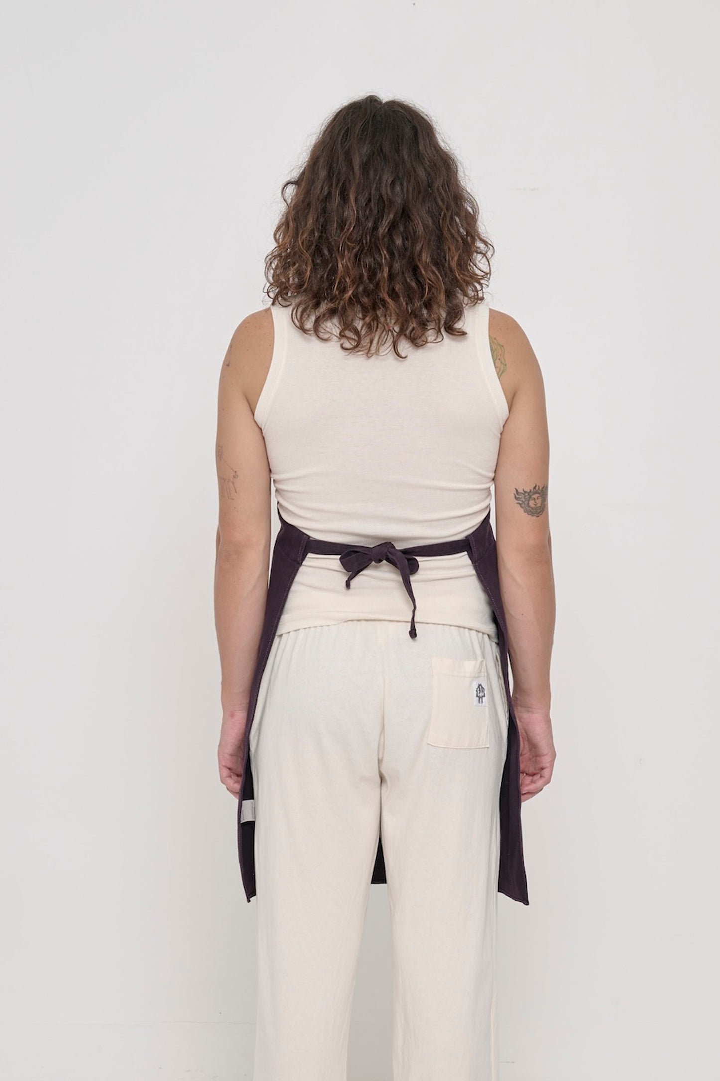 Rear view of a person in a Mulberry Adjustable Apron, showing the waist straps tied.