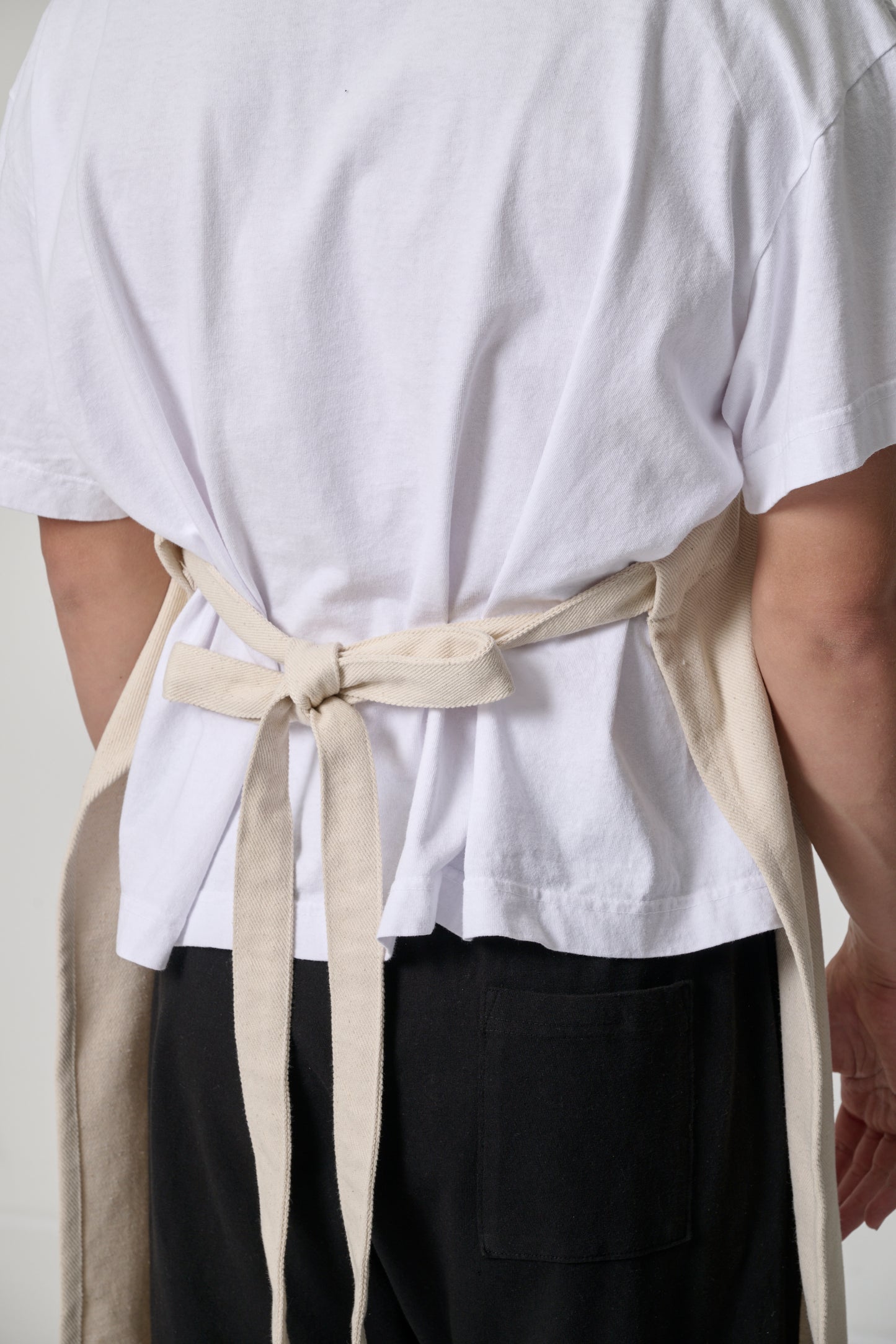 Close up back view showcasing stitching and straps tied at waist.