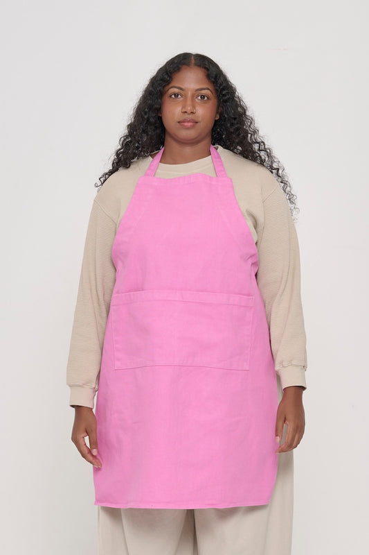 Front view of a person in an Adjustable Apron in Pixie, with straps tied behind their back.