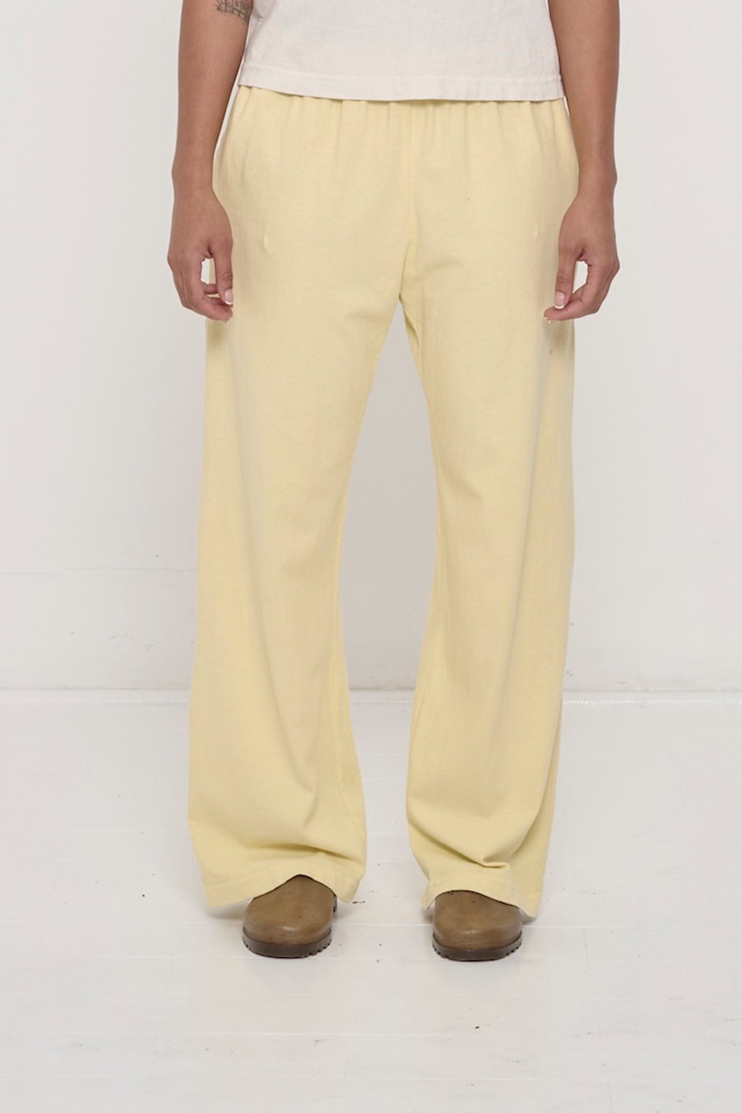 Waist down of a 5'8"person in Size M French Butter Apartment Pants. Relaxed drape. Hem at bottom of the heels.