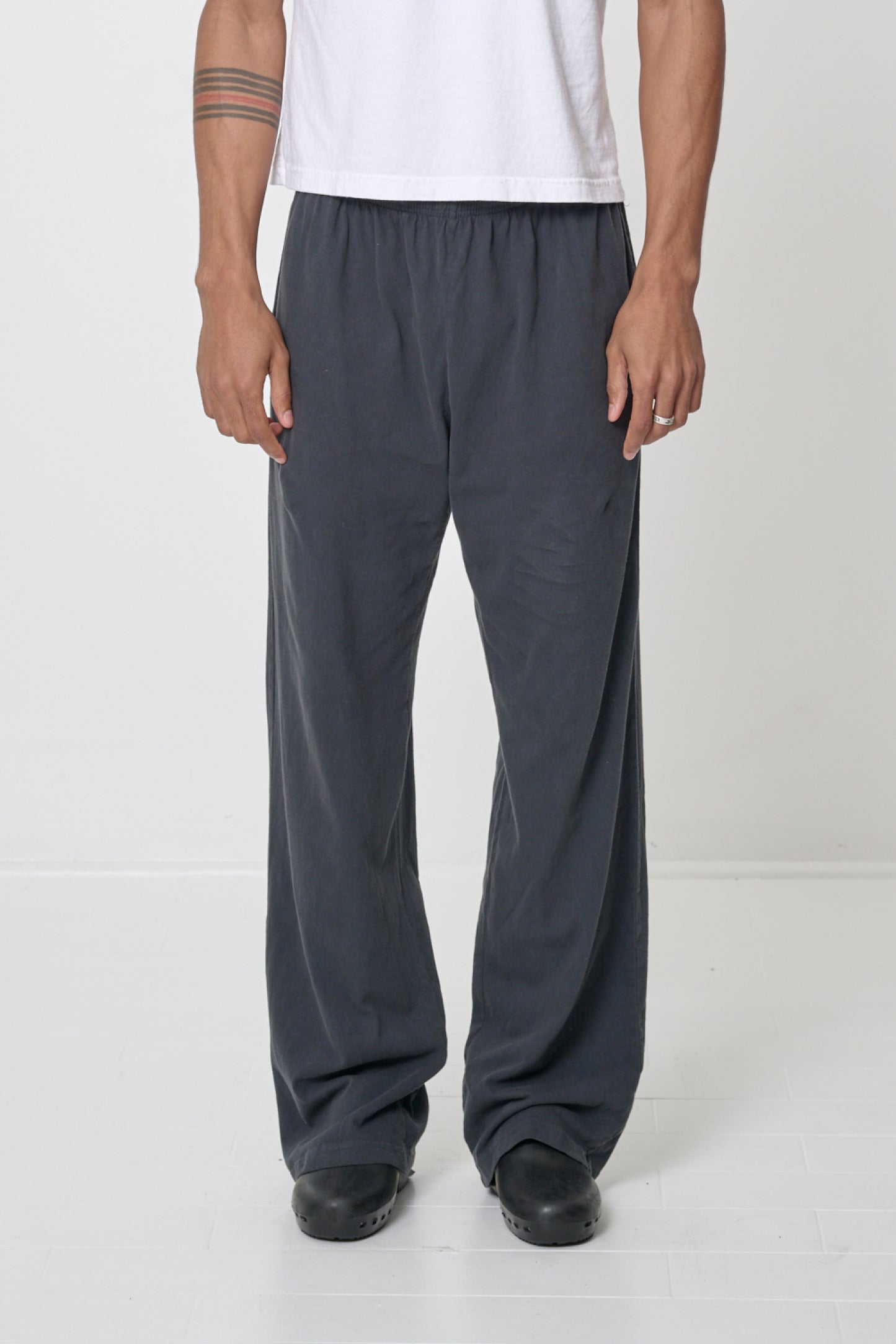 Waist down of a 6' person in Size L Slate Apartment Pants. Hem at bottom of the heels.