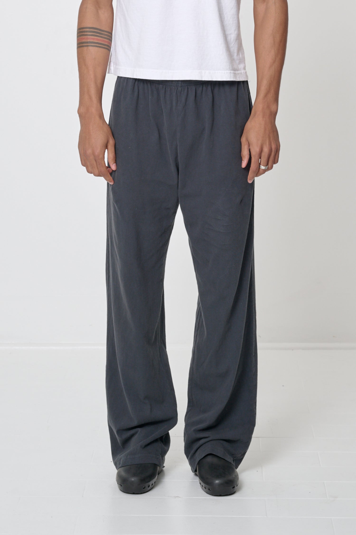 Waist down of a 6' person in Size L Slate Apartment Pants. Hem at bottom of the heels.