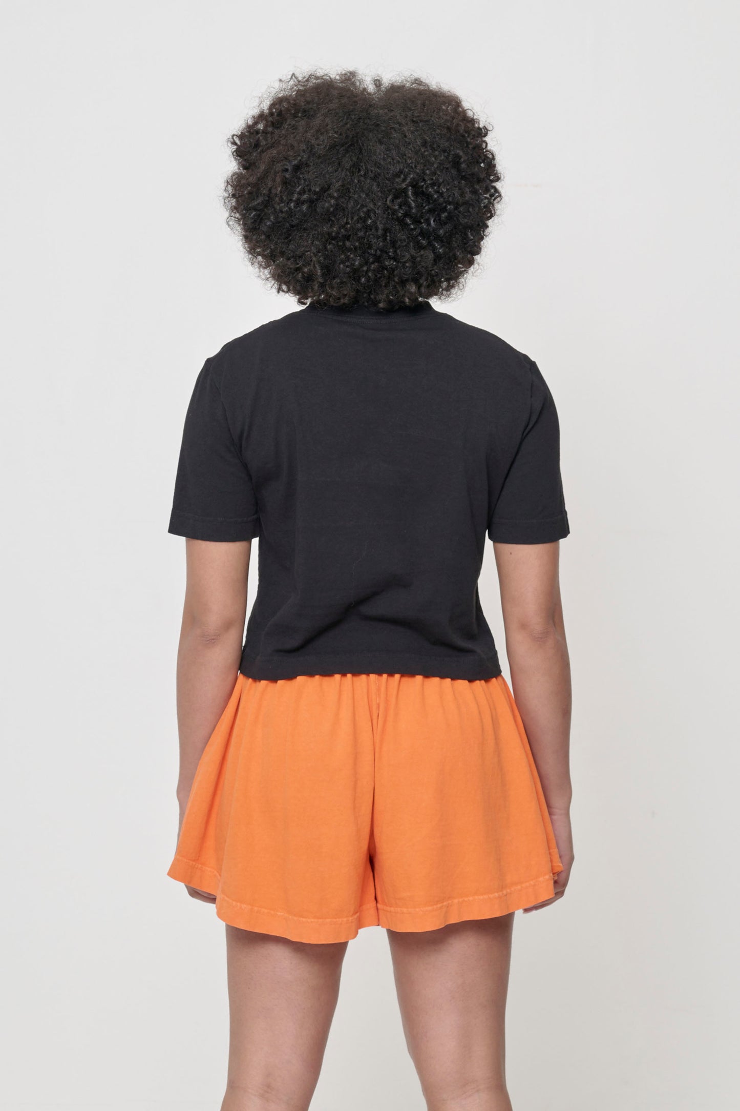Back view with fabric folds showing relaxed fit at lower back.