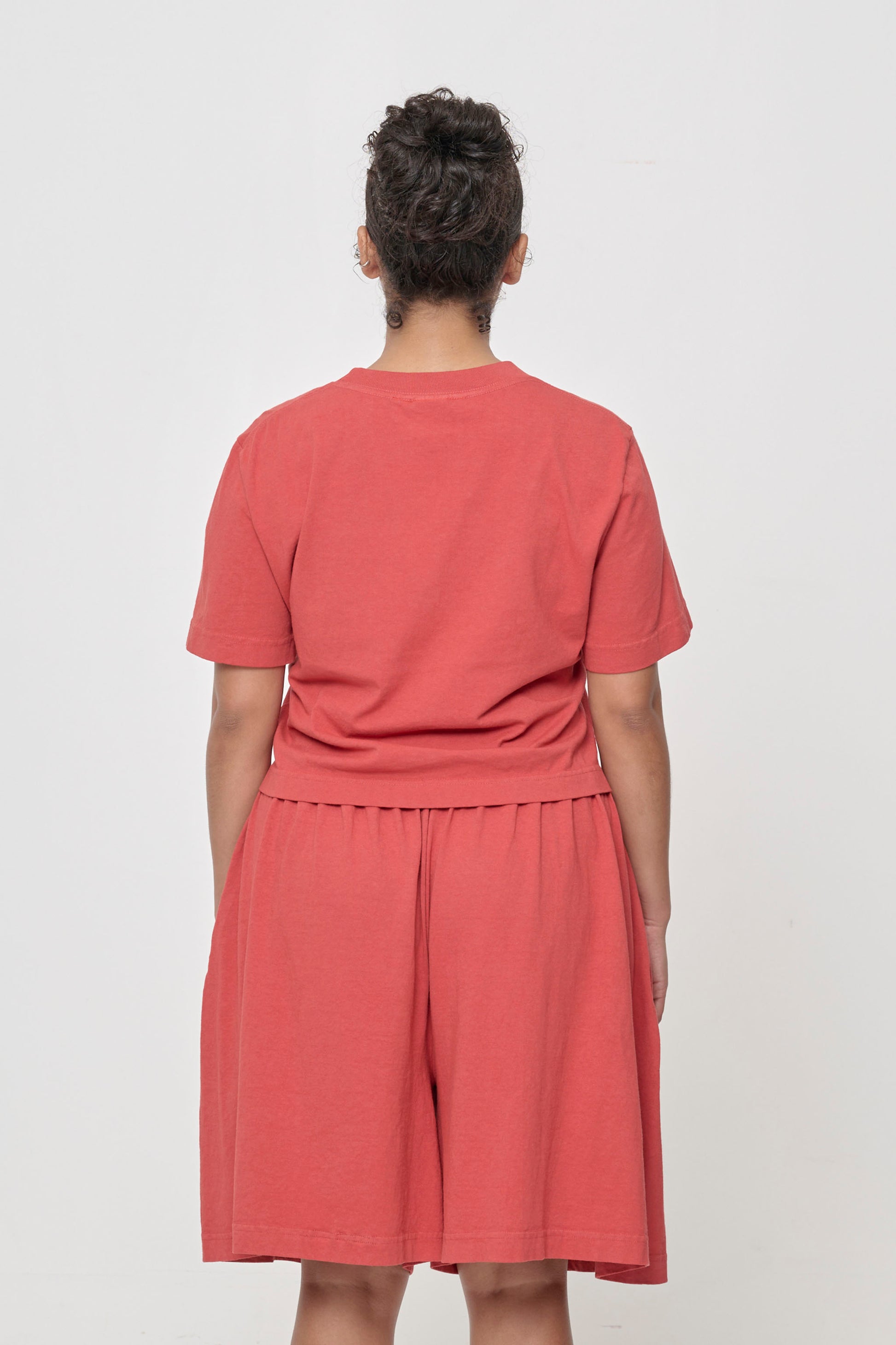 Back view with fabric folds showing relaxed fit at lower back.