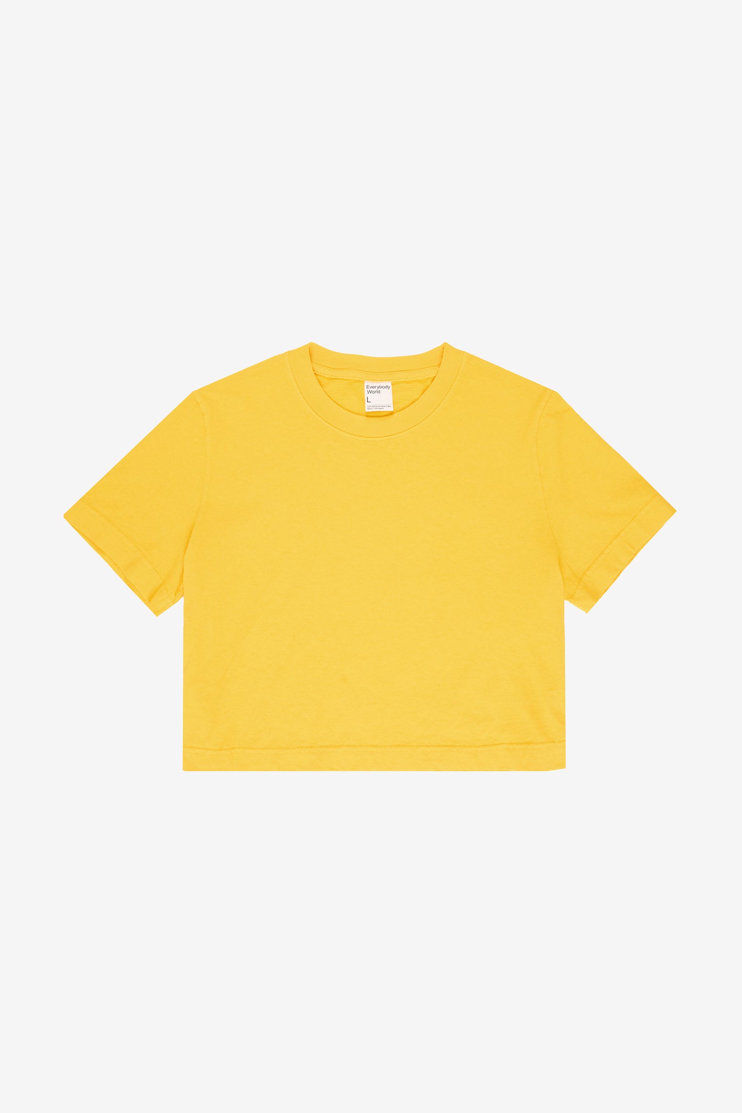 Flat lay of Everybody Yellow colored Baby Trash Tee on a light gray background