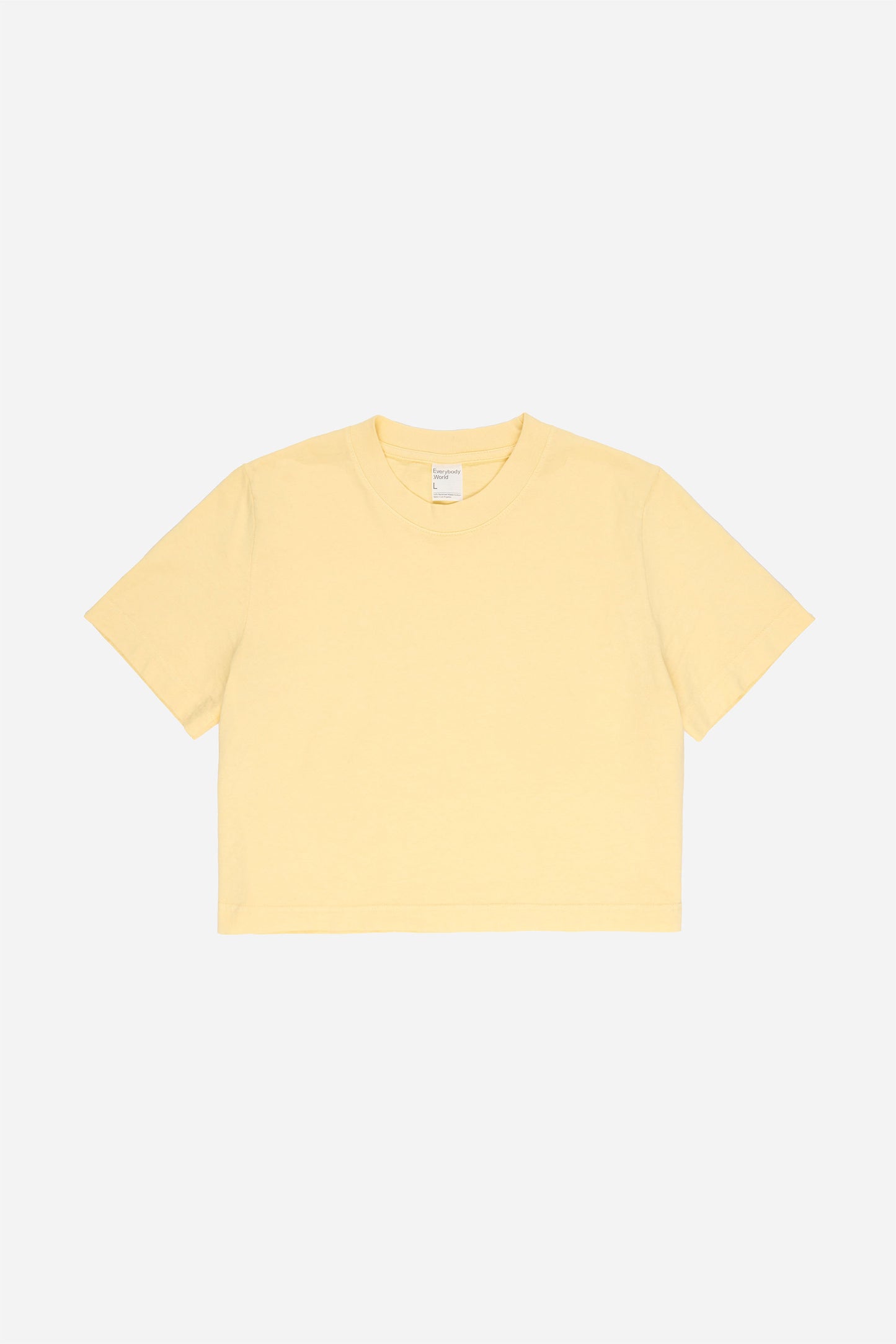 Flat lay showing light yellow t-shirt's silhouette and construction details
