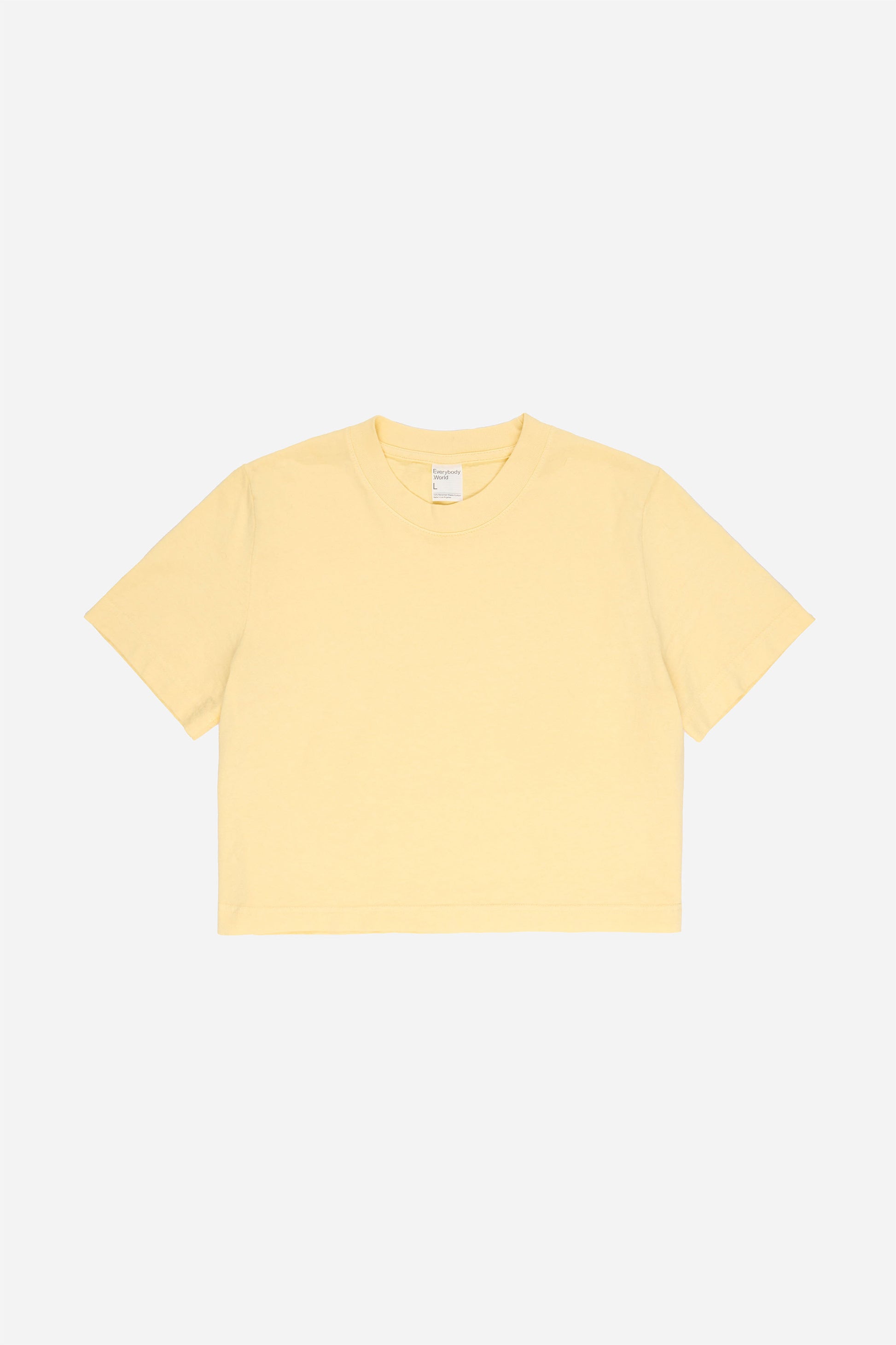 Flat lay showing light yellow t-shirt's silhouette and construction details