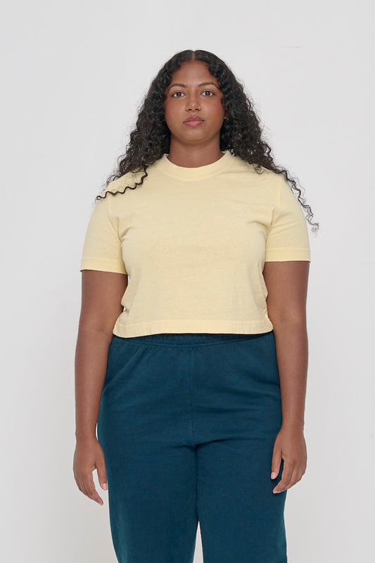 woman in a light yellow cropped t-shirt and bottom hem hitting top of pants waistband
