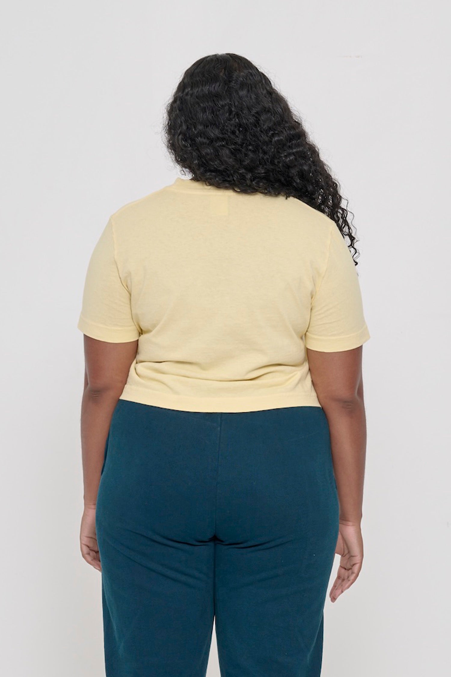Back view with fabric folds showing relaxed fit at lower back.