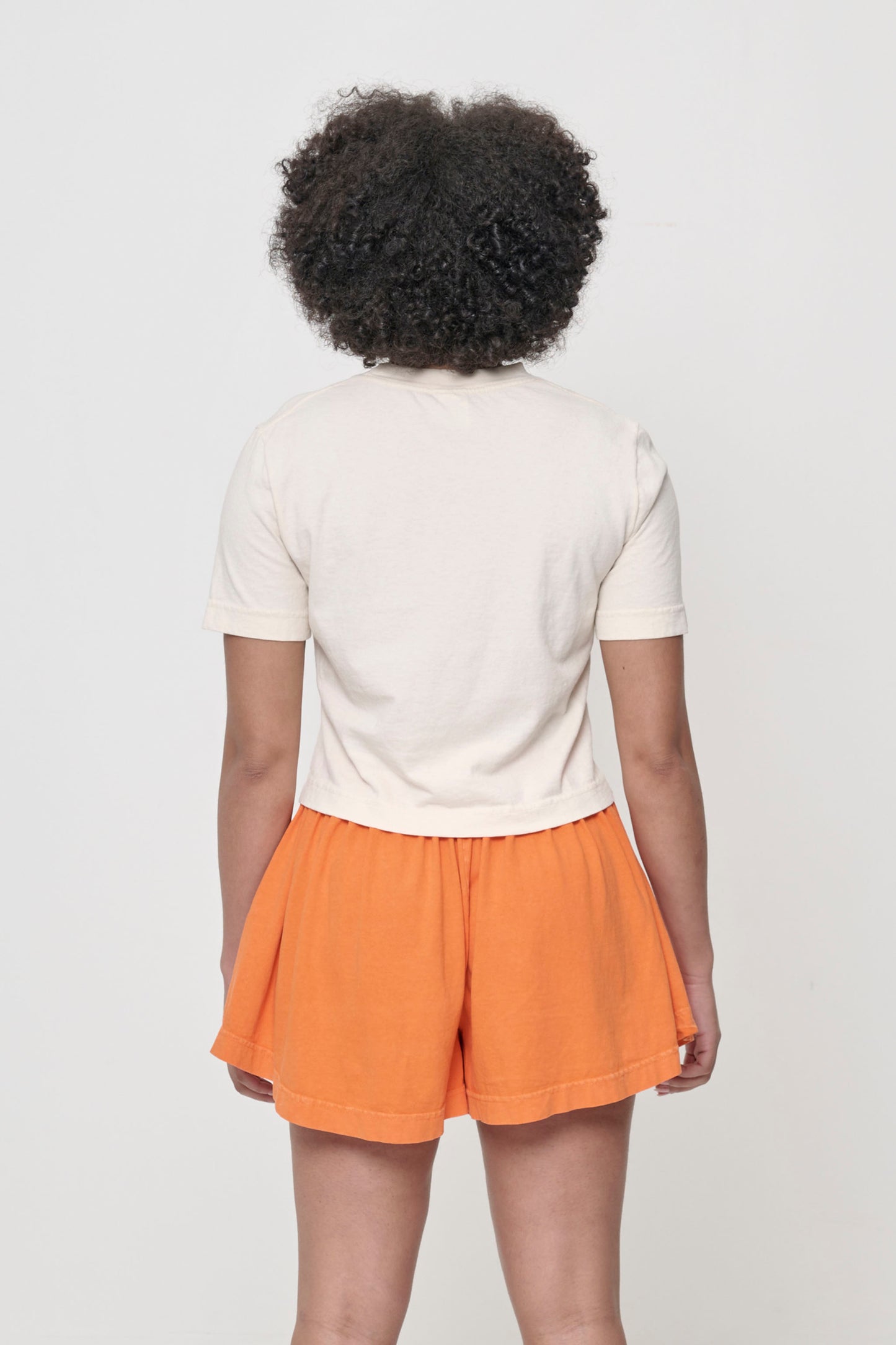Back view with fabric folds showing relaxed fit at lower back.