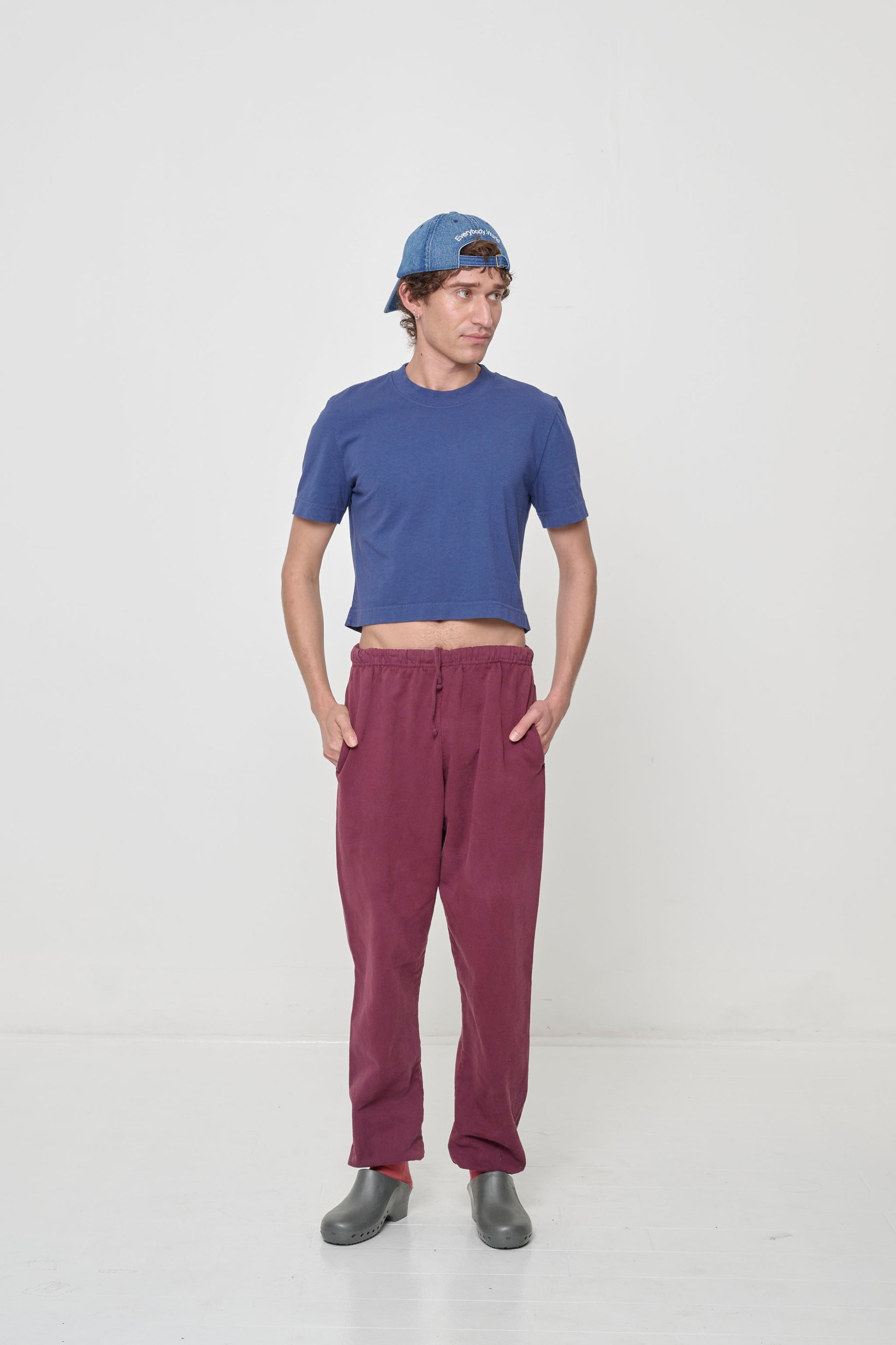 Styled with hands in sweatpants pockets, which raises shirt hem to expose lower midriff.