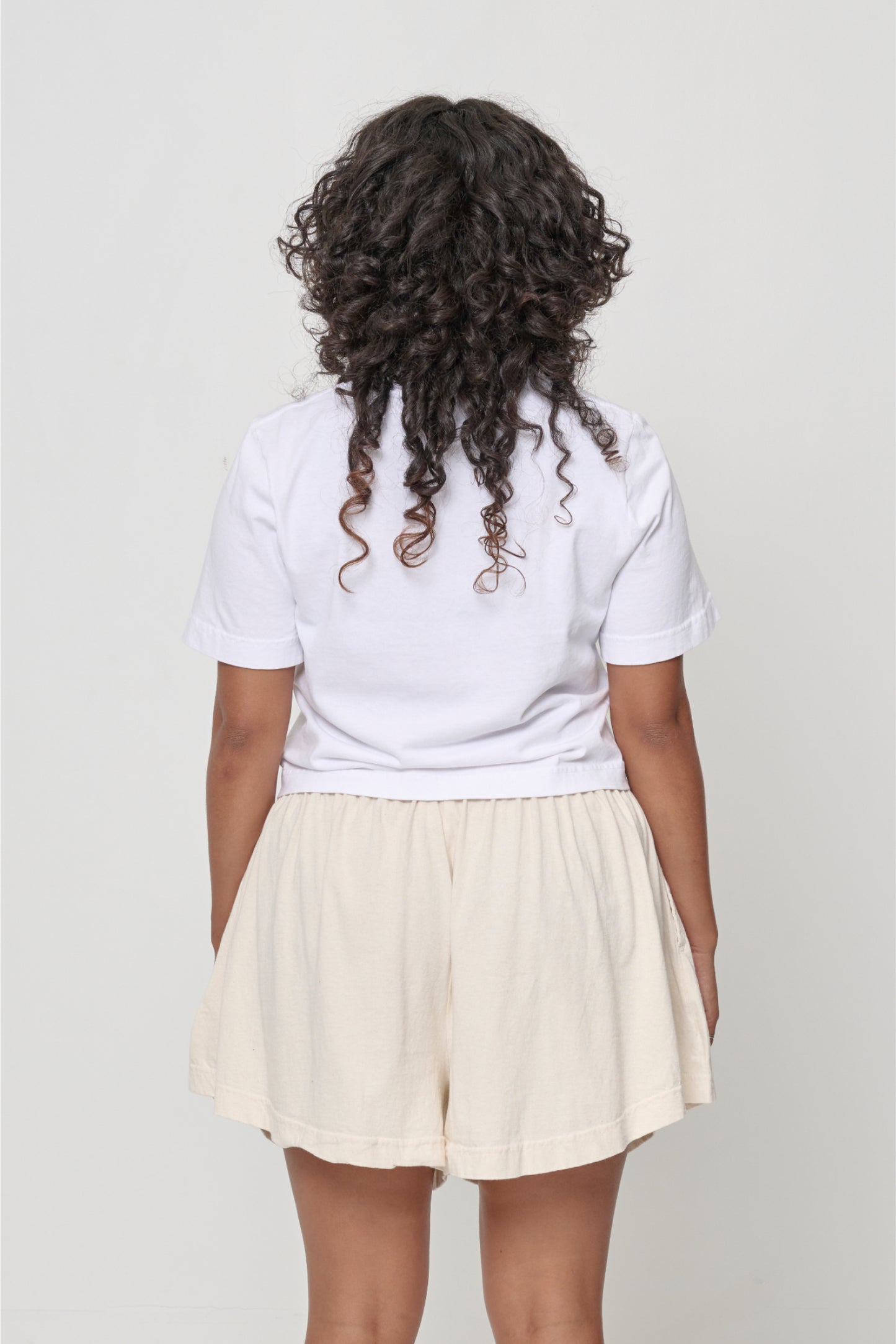 Back view with fabric folds showing relaxed fit at lower back.