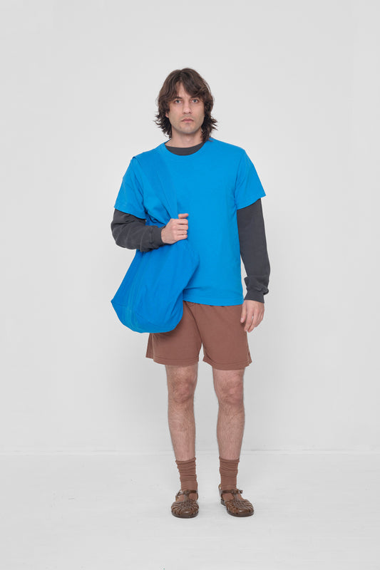 Man holding it over his shoulder, showing that the bag opening begins at his mid-torso.
