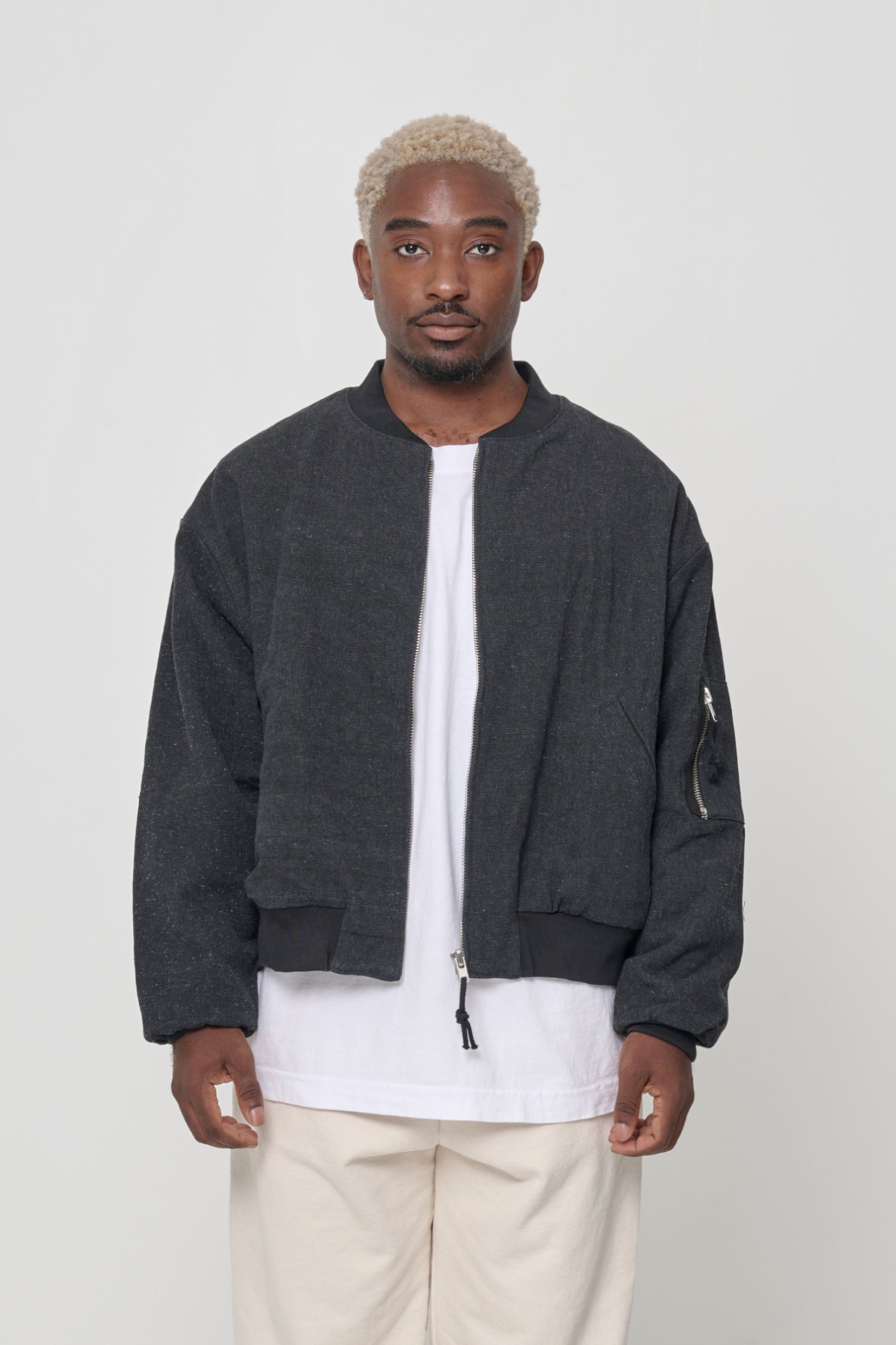 Person wearing the Biodegradable Bomber Jacket in Black, a charcoal heather color.
