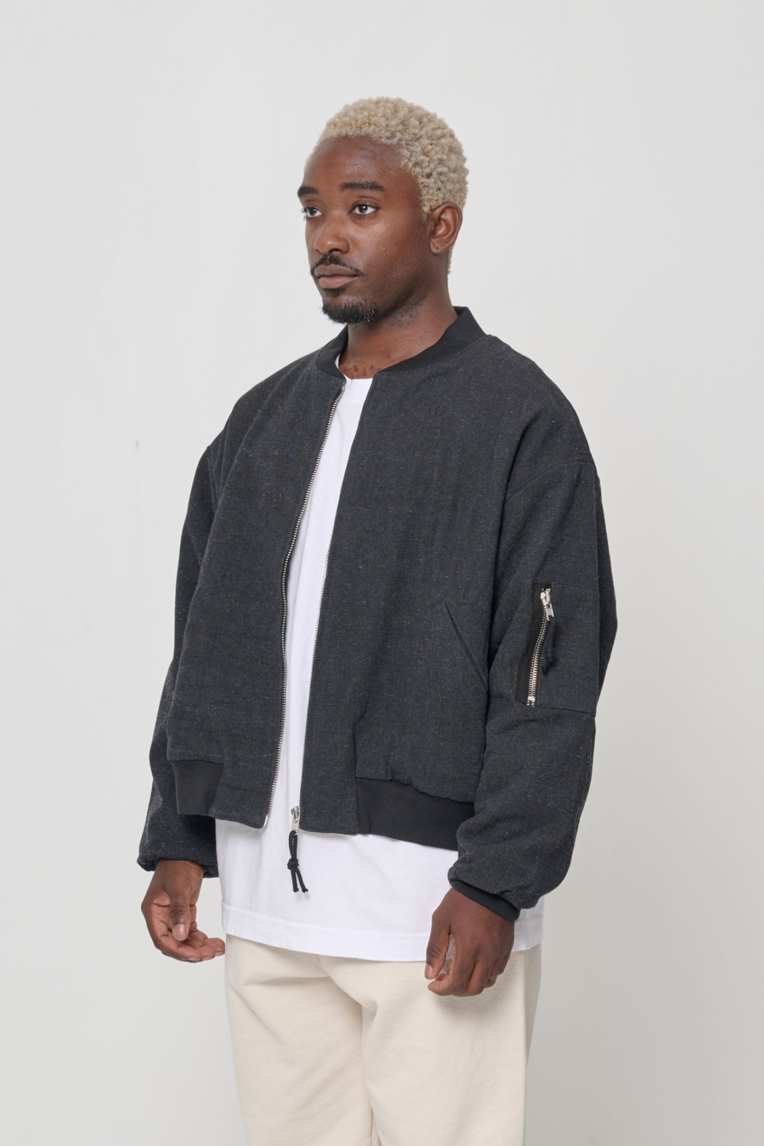 3/4 view highlighting sleeve patch pocket with metal zip.