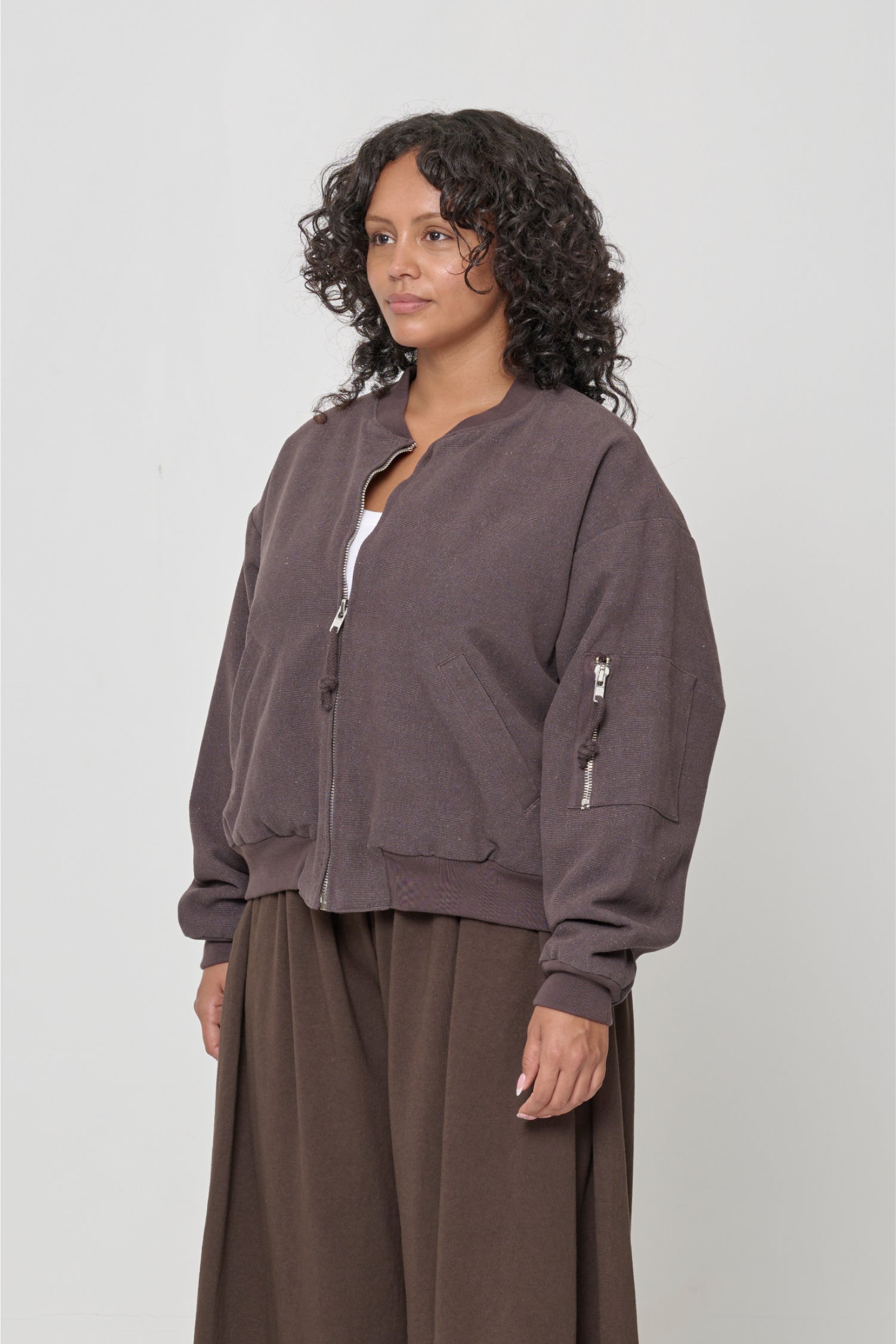 3/4 view highlighting sleeve patch pocket with metal zip.