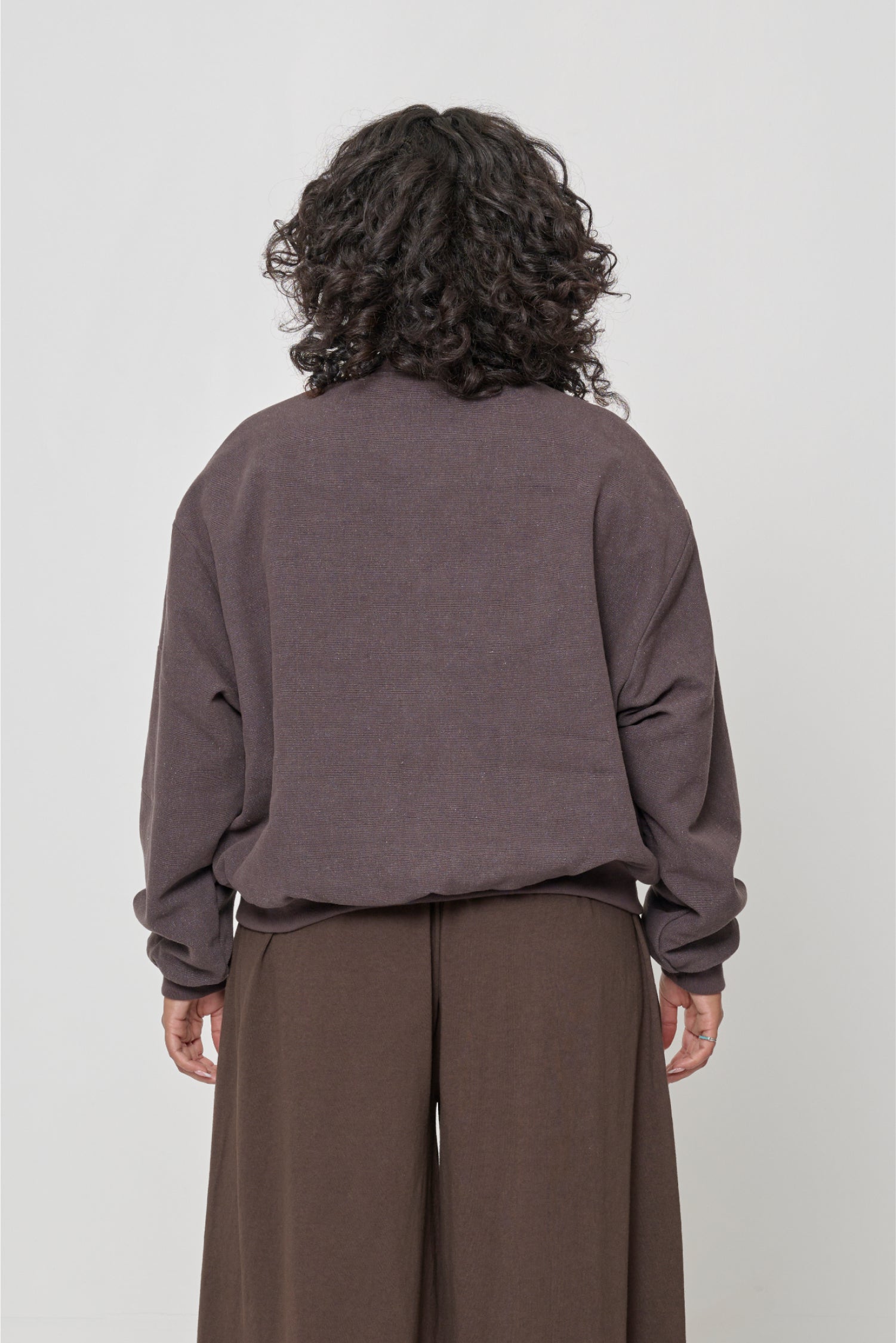 Back view with bottom hem hitting upper hip.