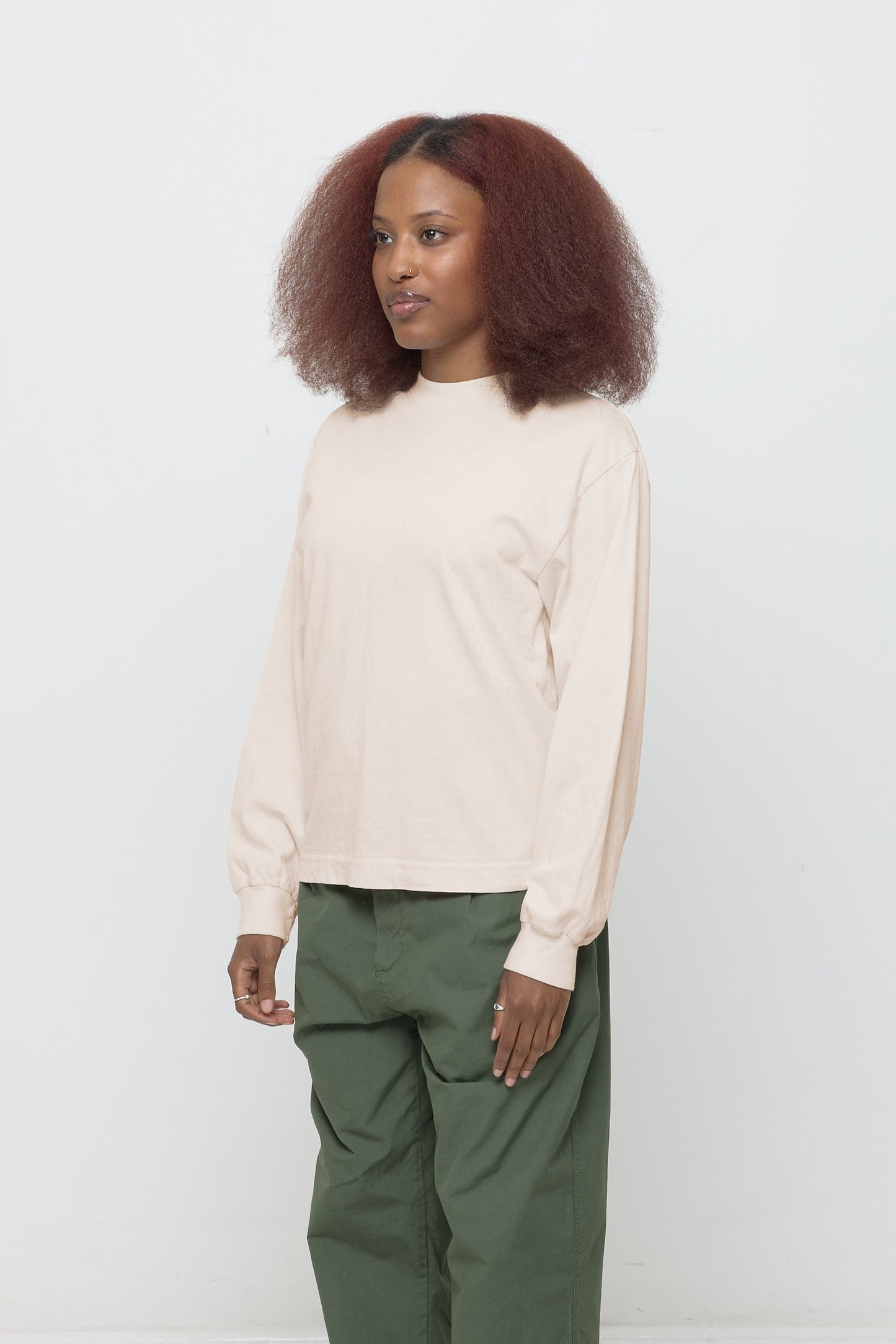 A person facing 45-degrees from the front shows relaxed sleeves and rib cuff.