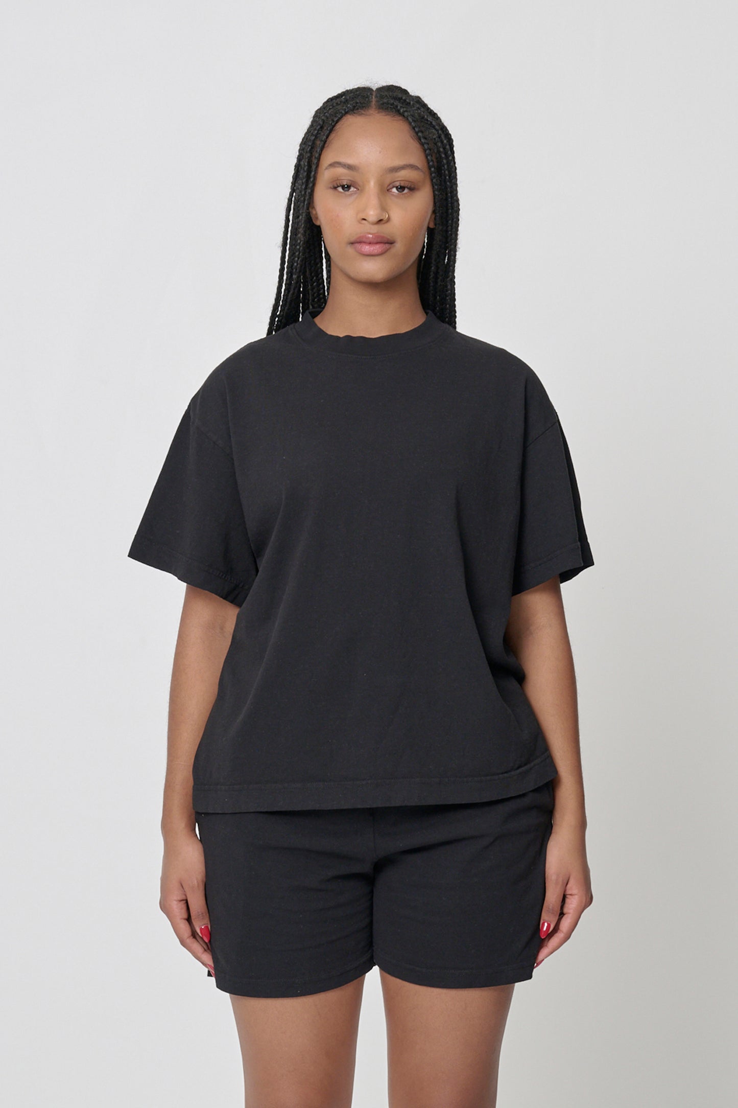 A 5'10" woman wearing a Black tee in size M. Bottom hem at the upper middle hip.