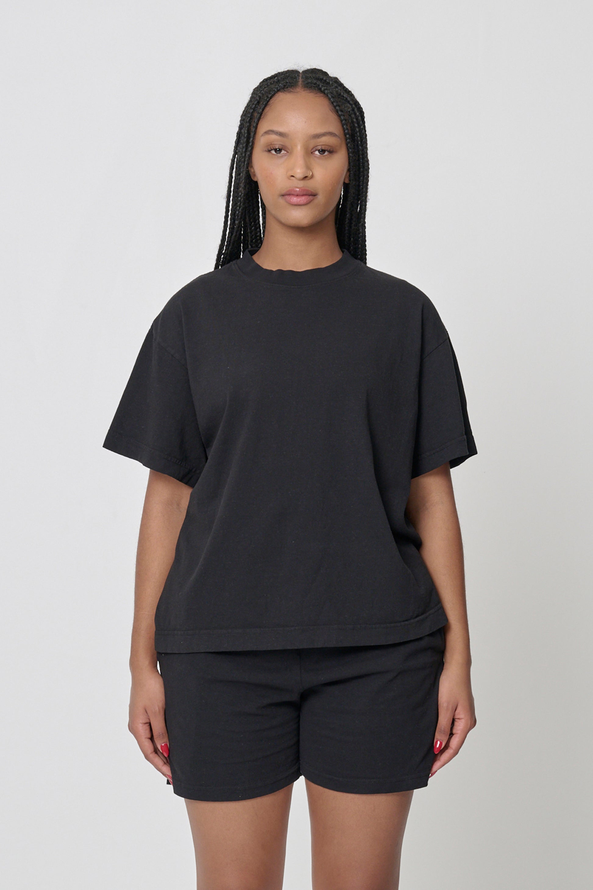 A 5'10" woman wearing a Black tee in size M. Bottom hem at the upper middle hip.