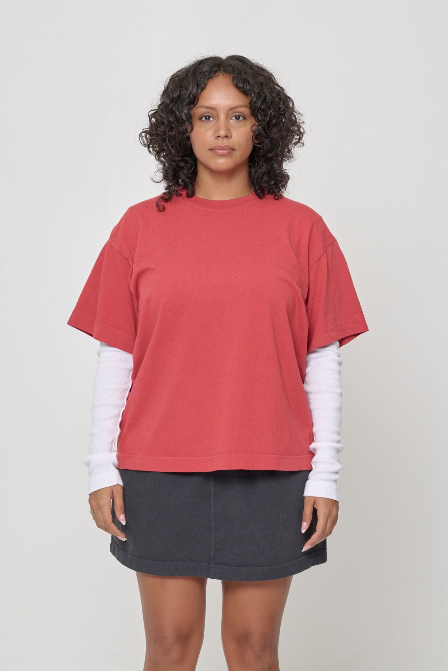 5'7" woman in a Cedar (orange red) Boxier Trash Tee in size M. Bottom hem at the lower middle hip.