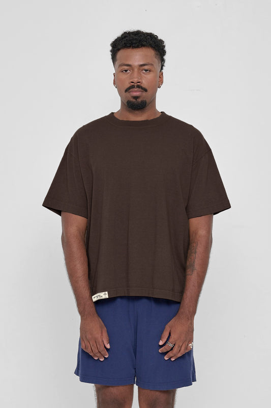 A 6'2" man in a size XL Boxier Trash Tee in Wet Soil. Hem at lower hip.