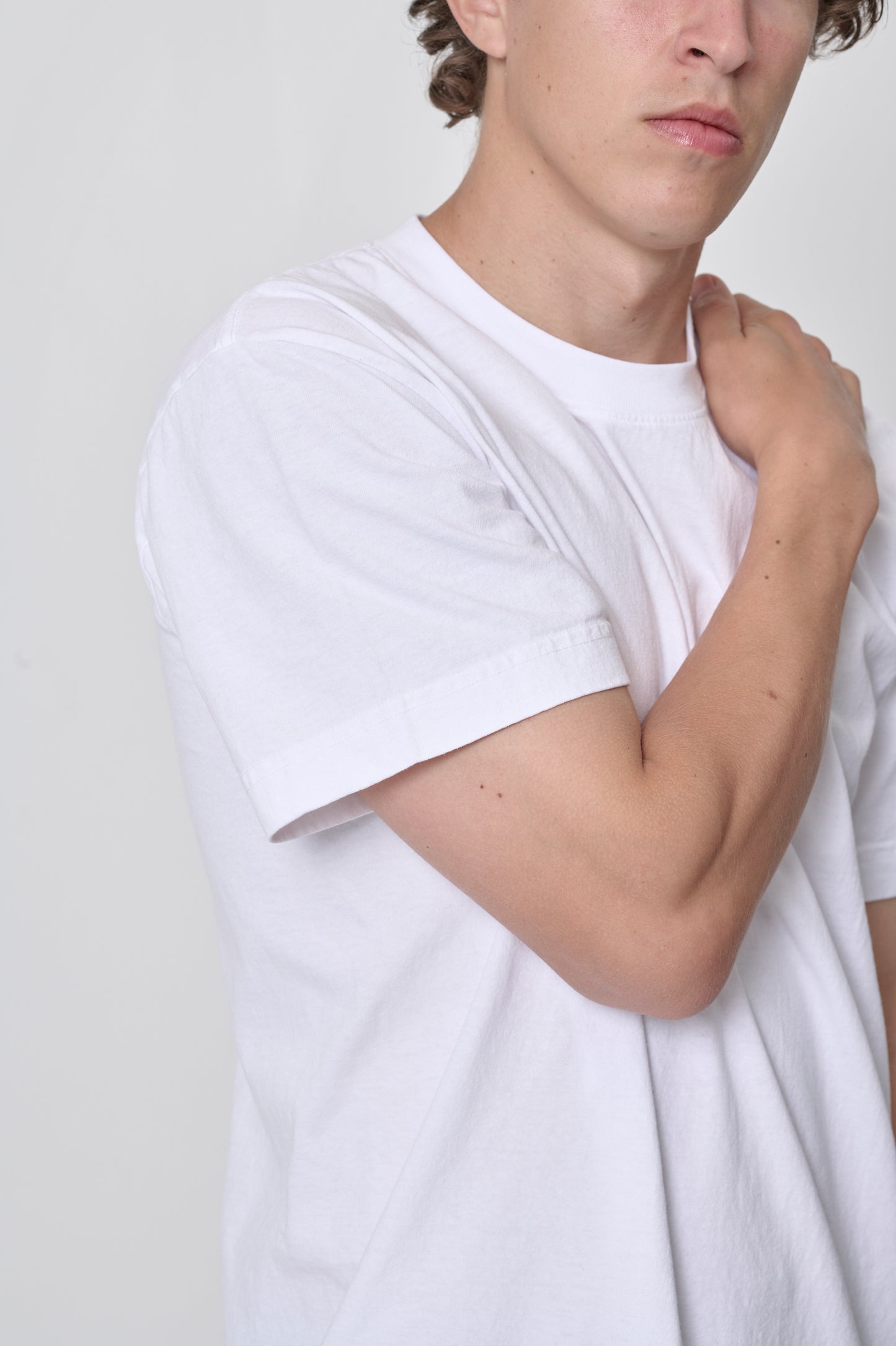 Close up of White Boxier Trash Tee showing detail of high crewneck, short sleeve, and tubular no side-seam body.