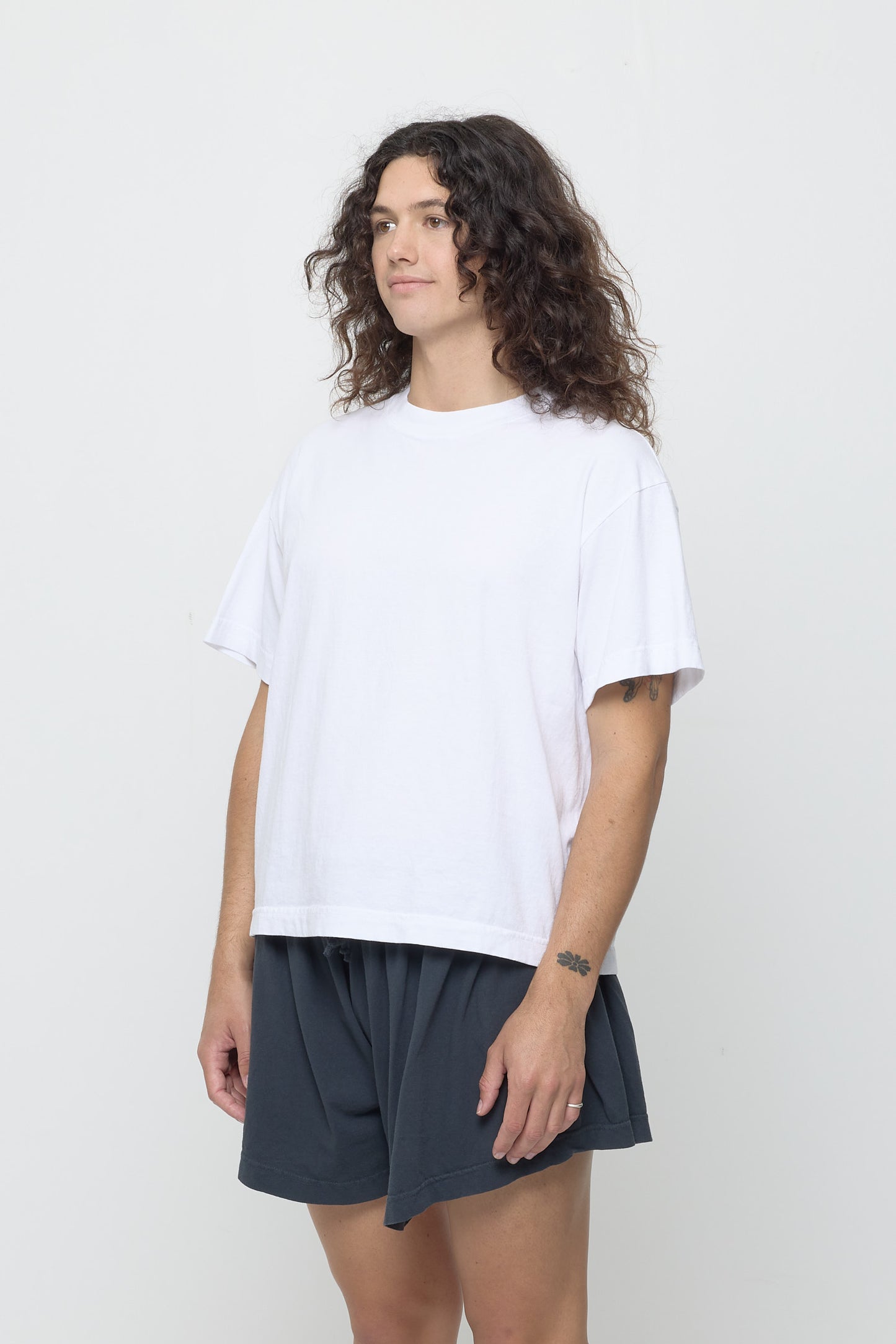 3/4 front view of person wearing White Boxier Trash Tee showing no side seams.