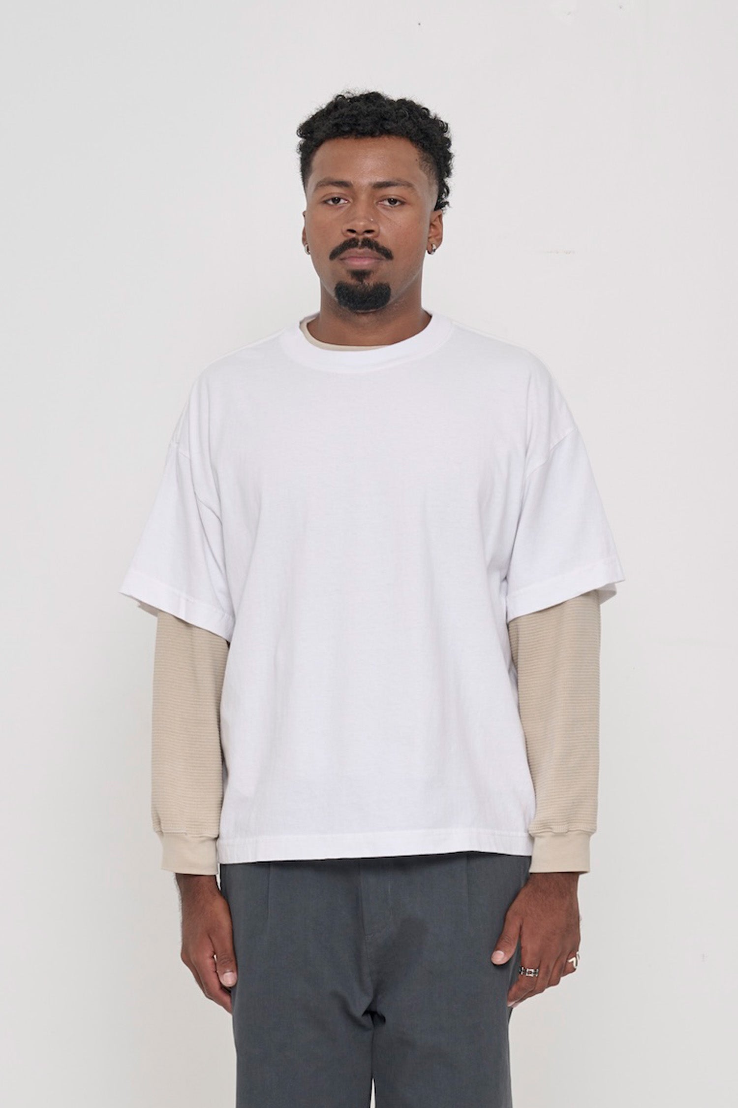 A 6'2" man in a size XL White Boxier Trash Tee. Hem at lower hip.