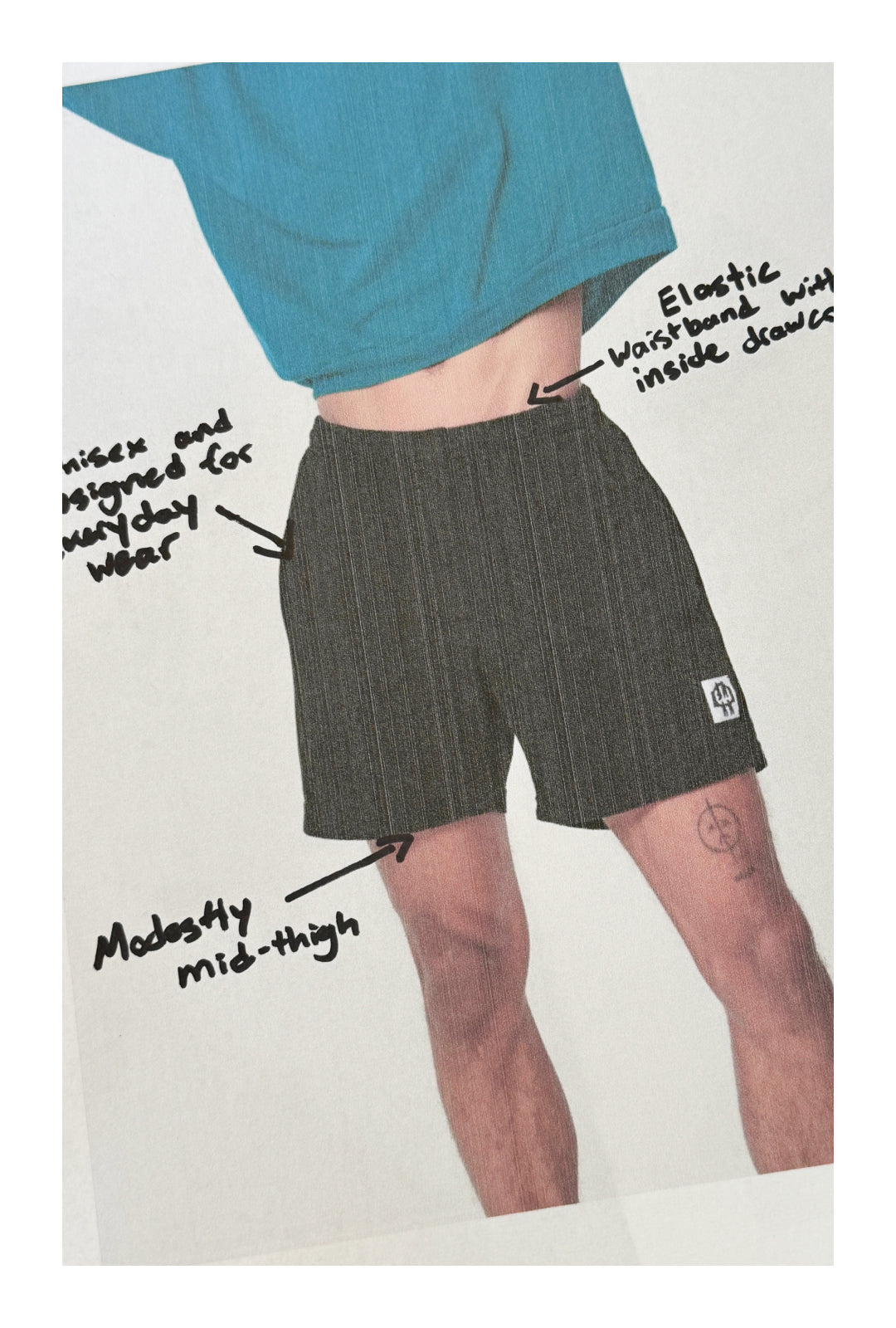 Model wearing Everyday Shorts with 3 label annotations: 1. Unisex and designed for everyday wear. 2. Elastic waistband with inside drawcord. 3. Modestly mid-thigh