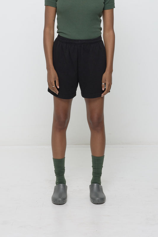 Person wearing Black Everyday Shorts and dark green Pine Squishy Socks on a white background