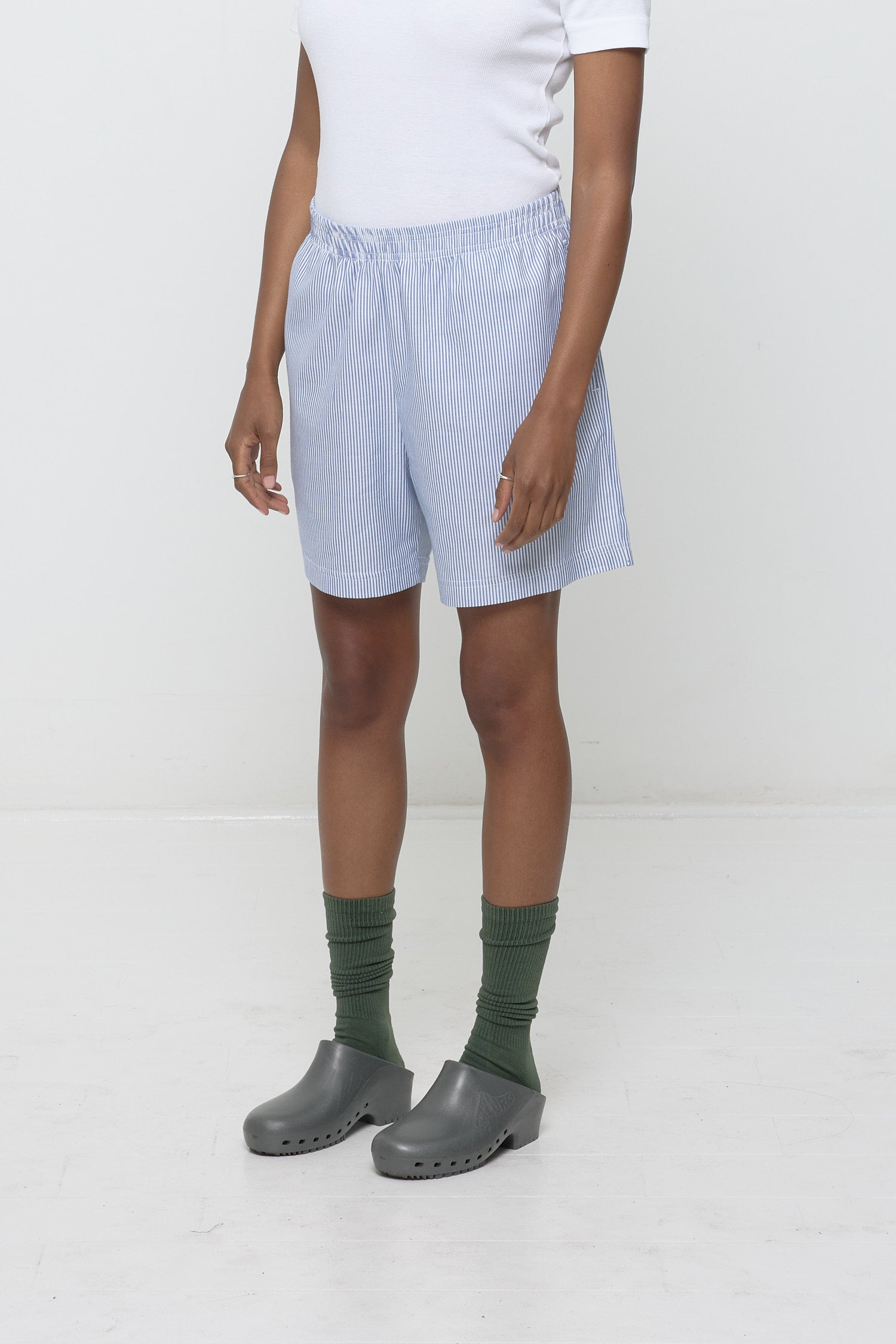 Close-up 3/4 view of Stripe Poplin Everyday Shorts on model. Highlights elastic waist and skinny blue and white stripes.