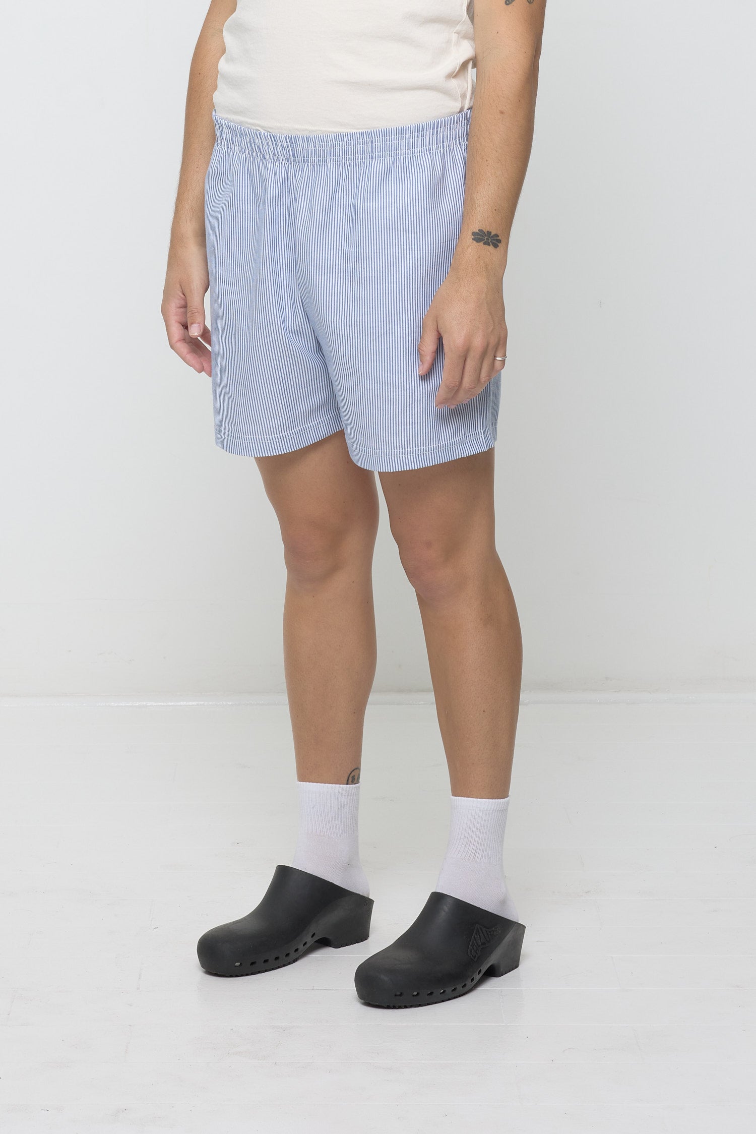 Close-up 3/4 view of Stripe Poplin Everyday Shorts on model. Highlights elastic waist and skinny blue and white stripes.