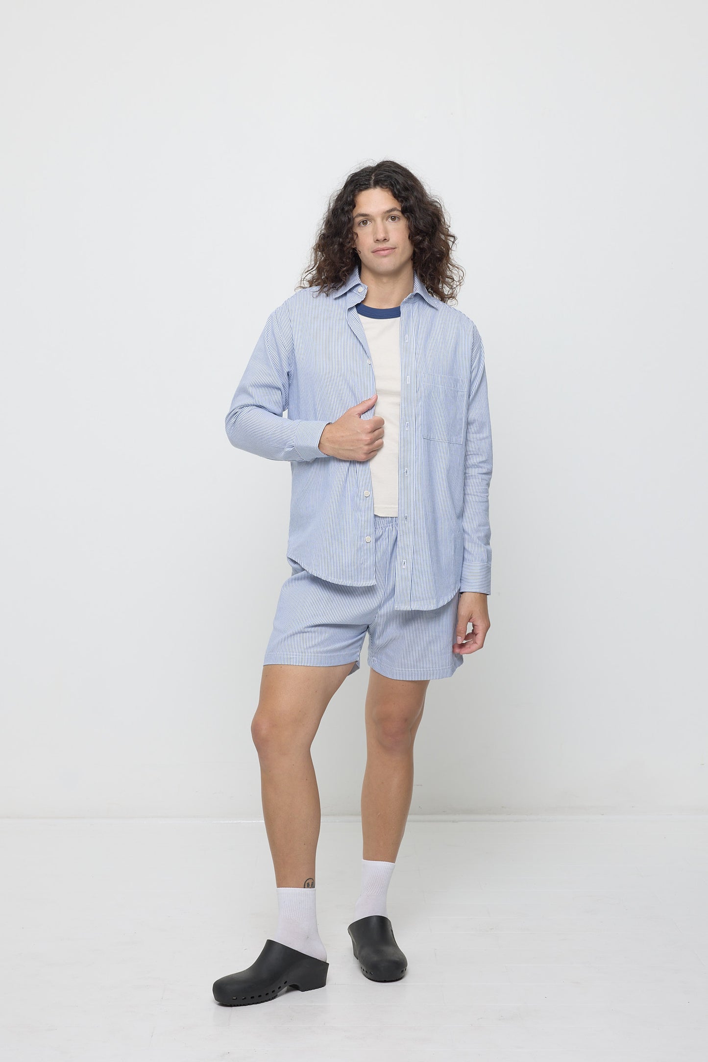 Person in Stripe Poplin Everyday Shorts and matching Stripe Poplin Button Up, open over a Washed Navy Ringer Trash Tee.