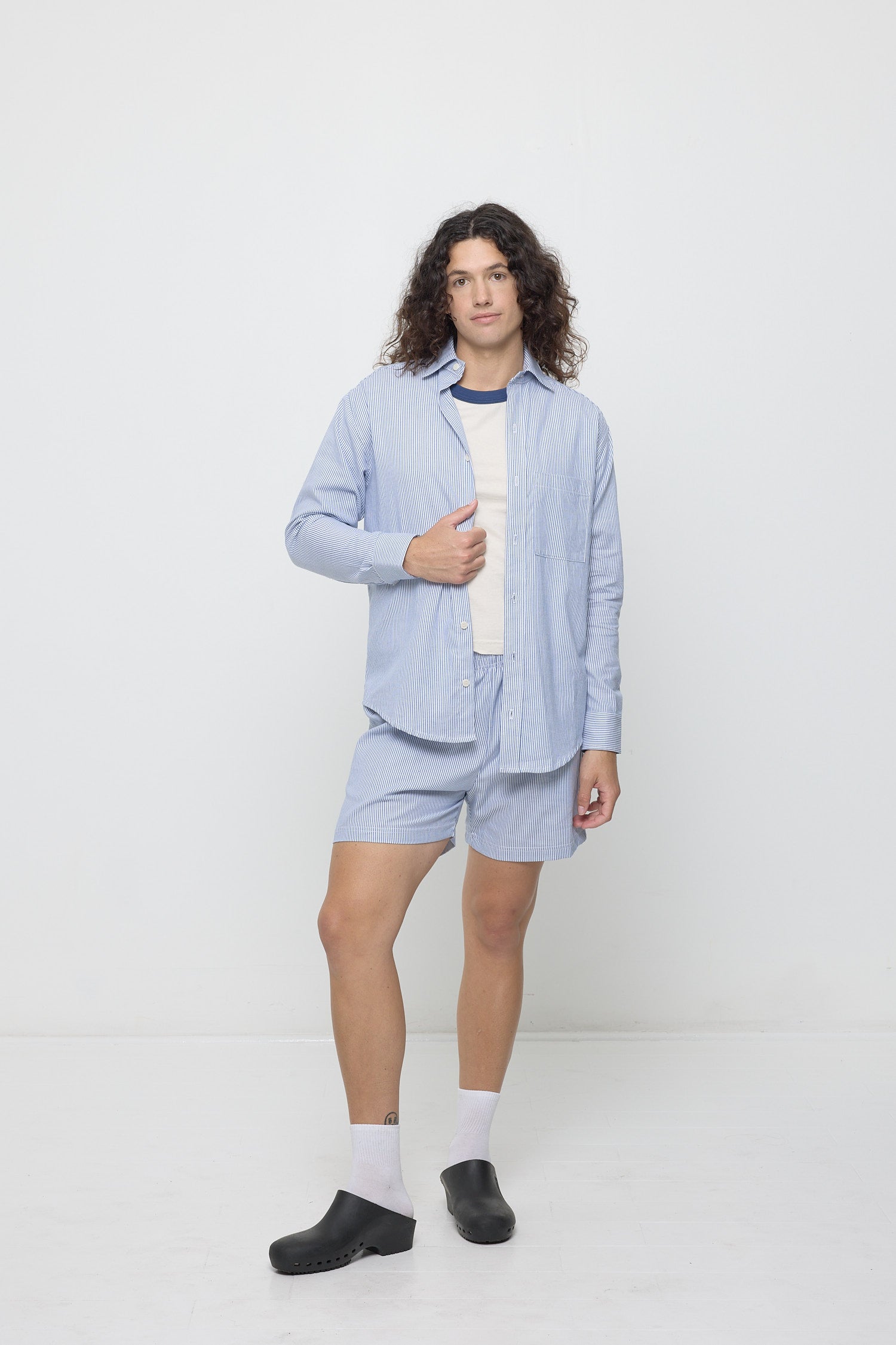 Person in Stripe Poplin Everyday Shorts and matching Stripe Poplin Button Up, open over a Washed Navy Ringer Trash Tee.