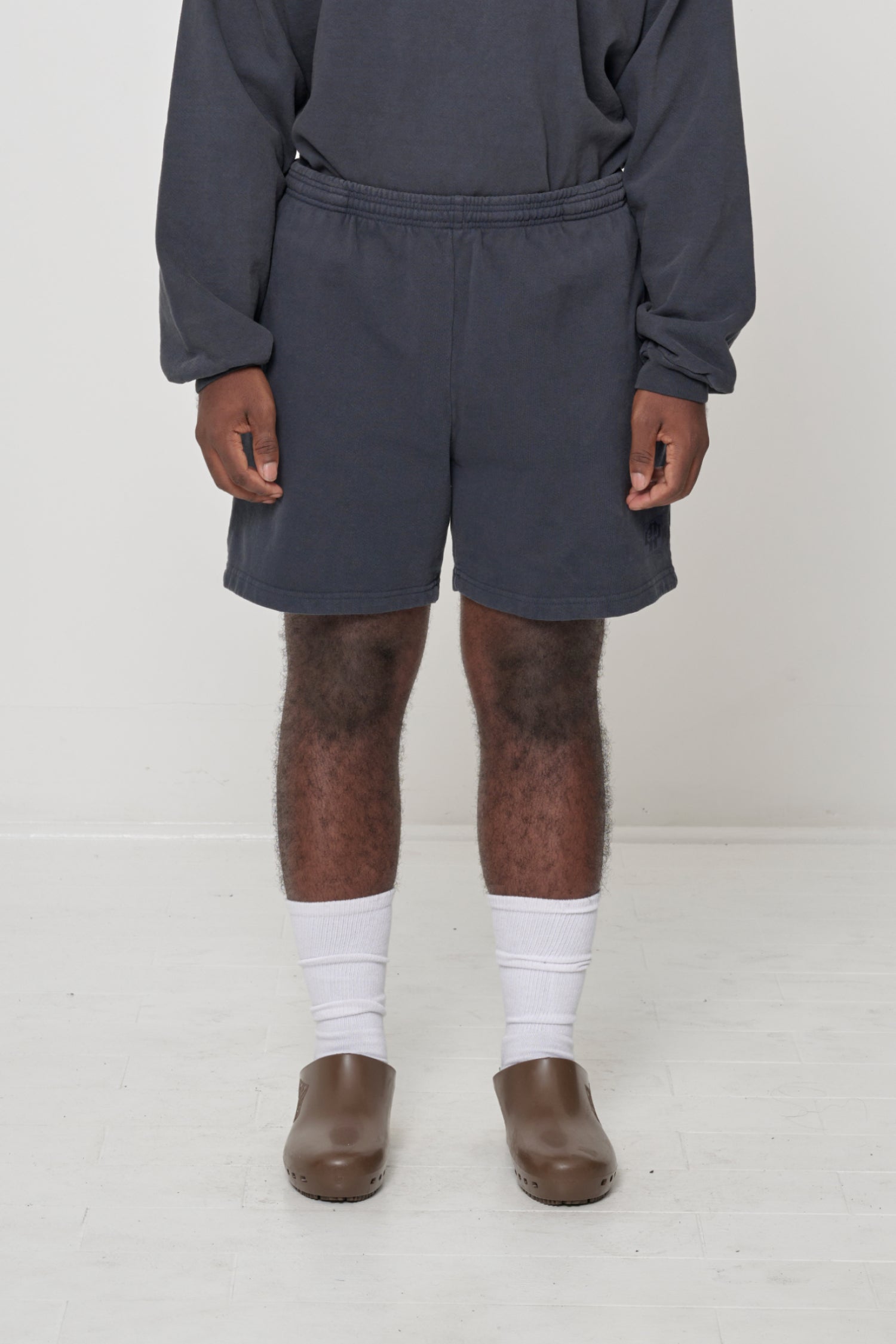 Slate Trash Fleece Everyday Shorts on model, front. Relaxed fit, elastic waist, small logo patch on left thigh.