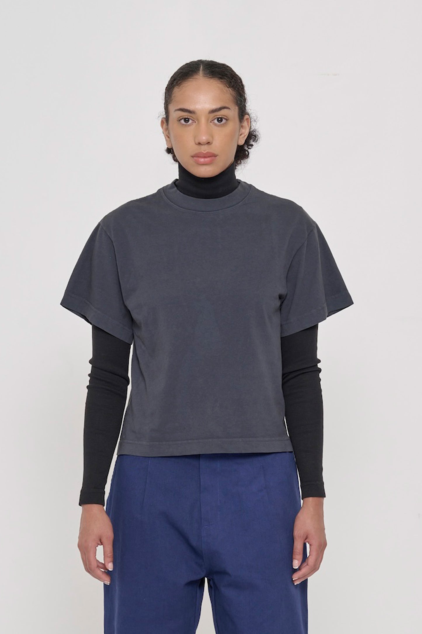 A 5'8" woman wearing Slate Heavyweight Boxier Trash Tee in size XS. Bottom hem cropped to upper hip.