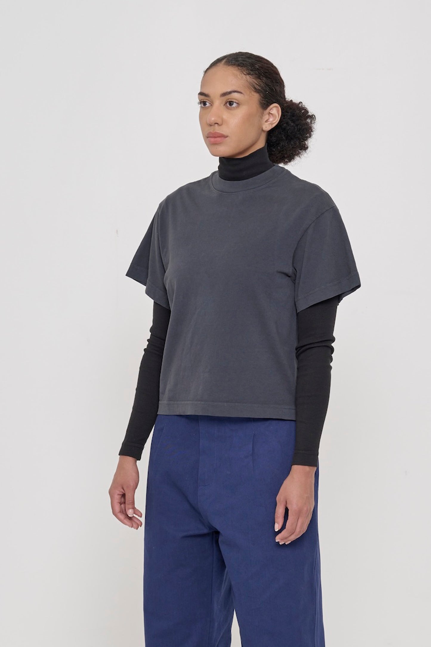 ¾ front view of a woman in a Slate Heavyweight Boxier Trash Tee: no side seams, wider than traditional short sleeves.