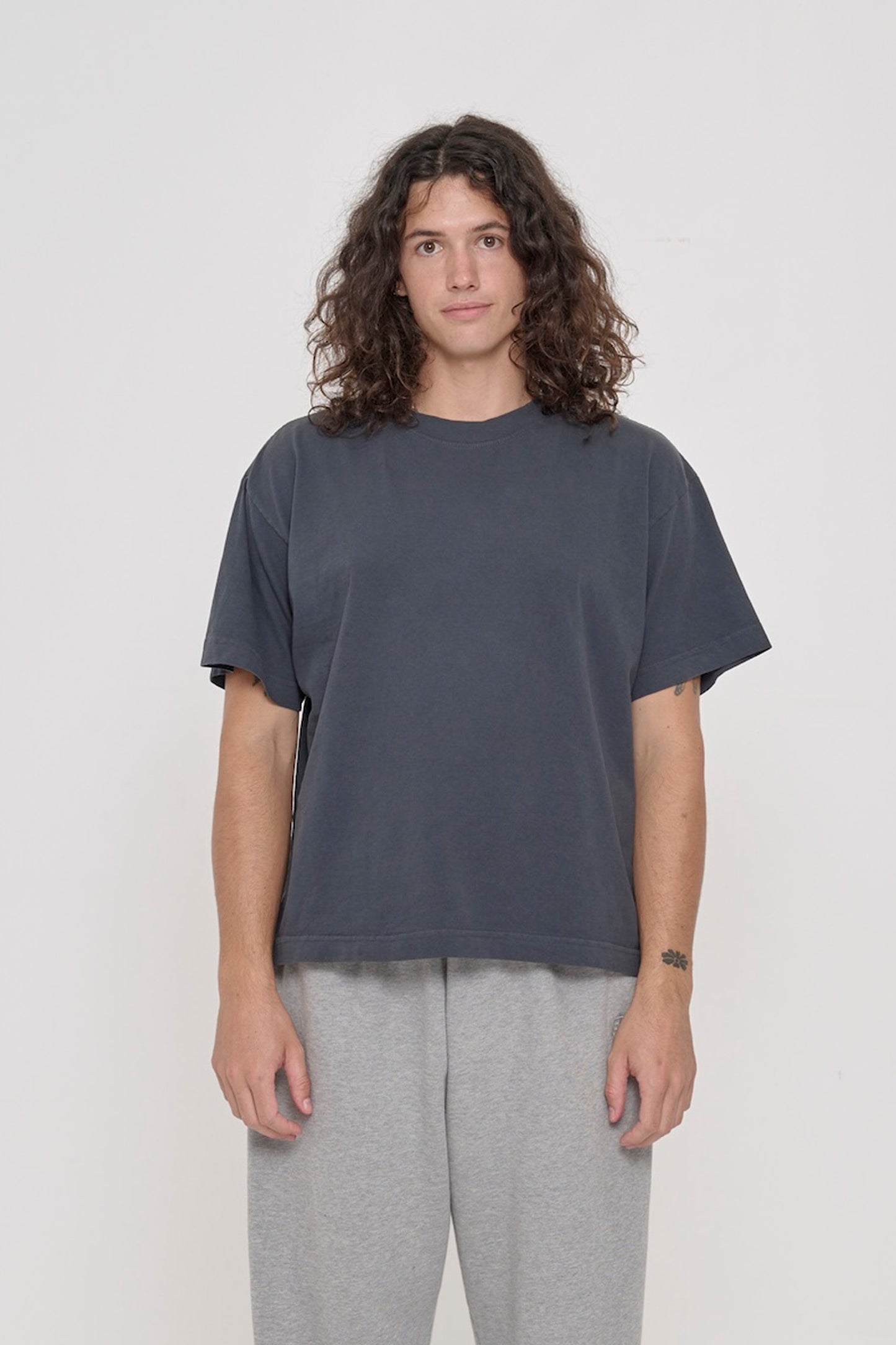 A 6' tall person wearing a Slate Heavyweight Boxier Trash Tee in size M. Hem is at their mid hip.