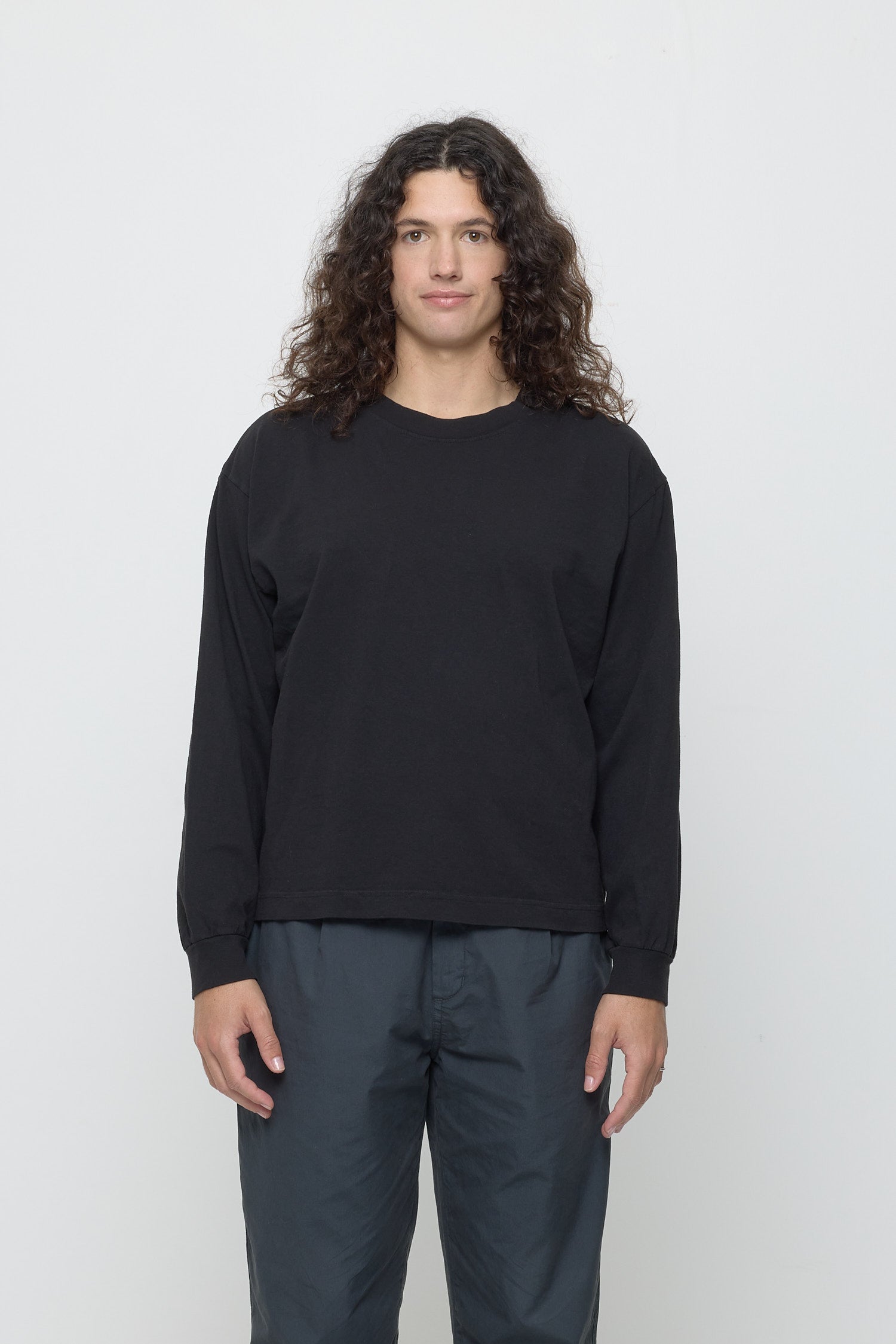 A 6'0" person in a Black Long Sleeve Boxier Trash Tee in size M. Hem hits the top of the hip.