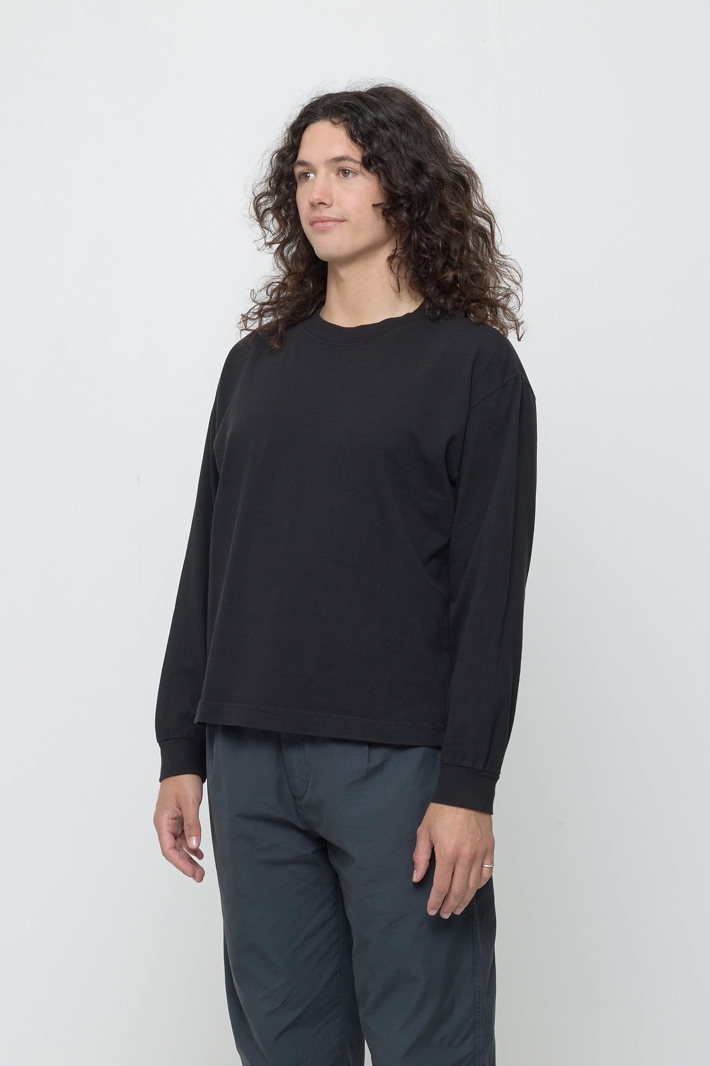 A person facing 45-degrees from the front shows relaxed sleeves and rib cuff.