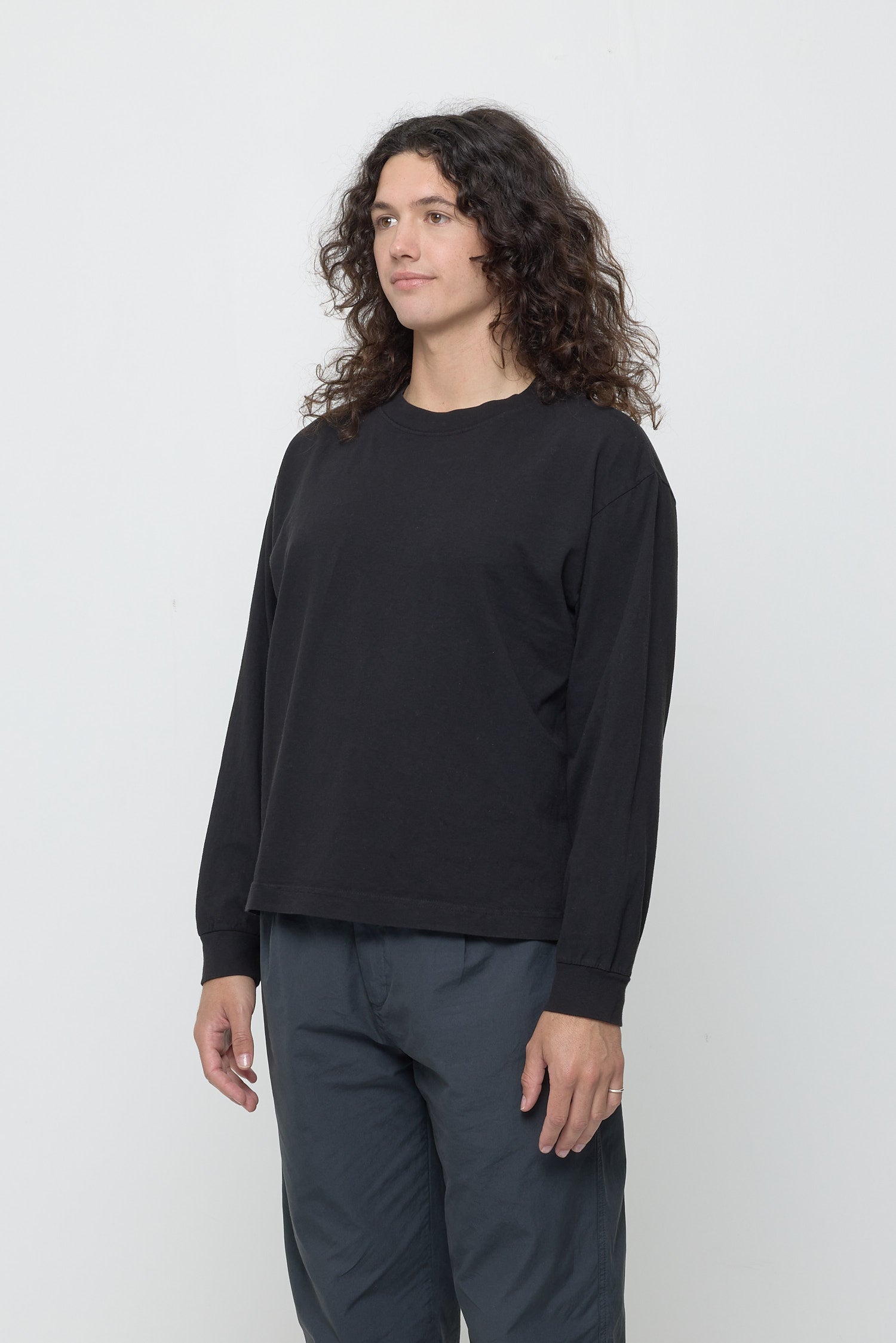 A person facing 45-degrees from the front shows relaxed sleeves and rib cuff.