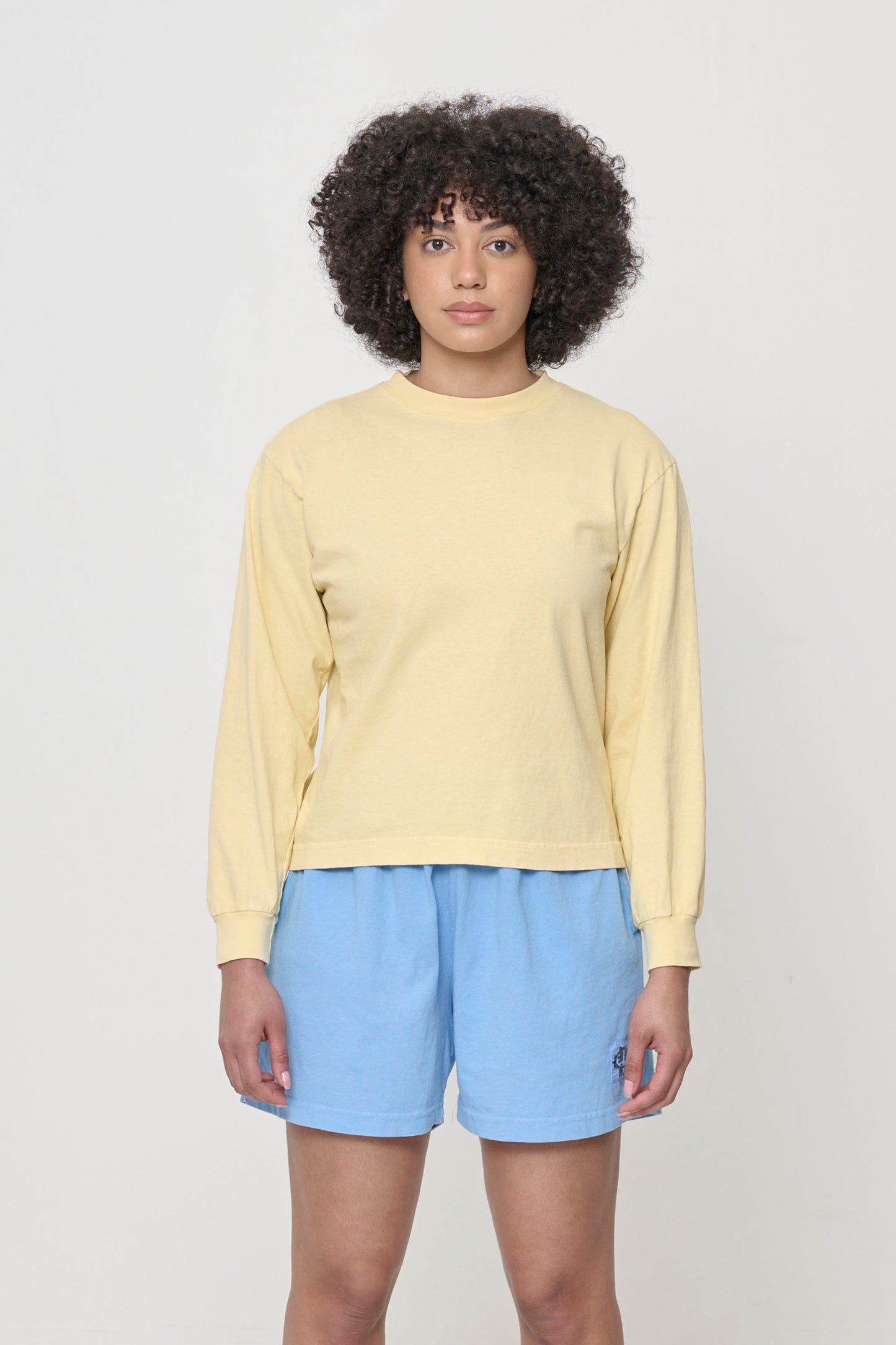 5'8" woman in a French Butter Long Sleeve Boxier Trash Tee. Hem hits her upper-middle hip.