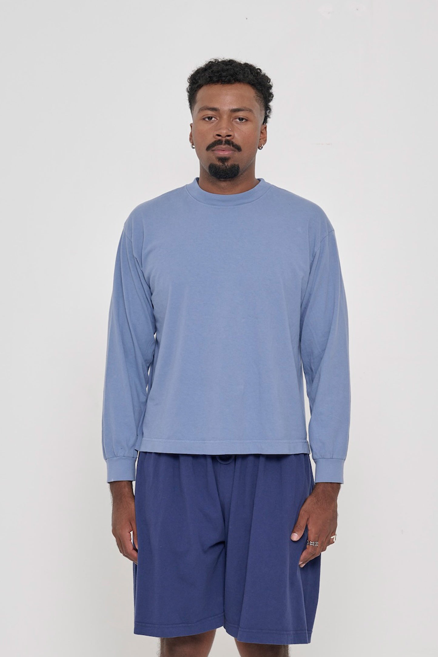 A 6'2" man in a size M Periwinkle Long Sleeve Boxier Trash Tee. Hem hits his upper middle hip.