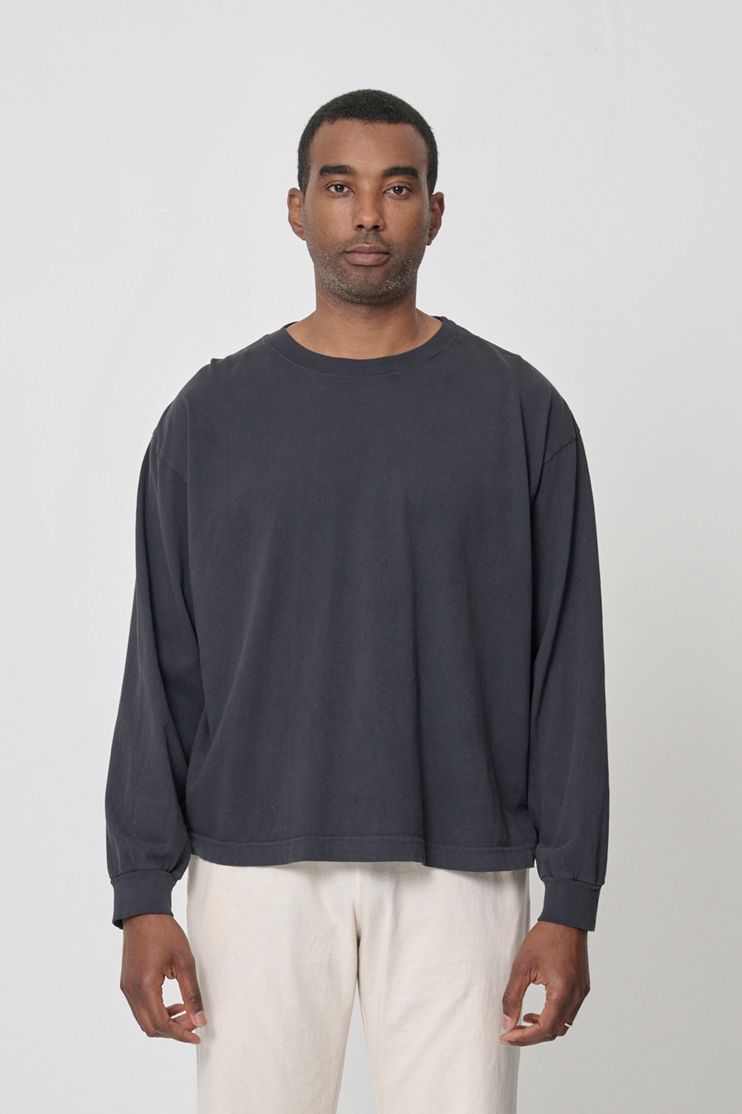 A 6'2" person wearing Slate Long Sleeve Boxier Trash Tee in size XL. Their arms are straight down at their sides and shirt hem hits the middle of the hip.