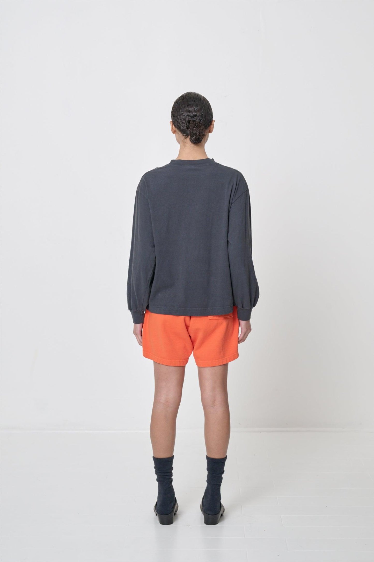 Back view of 5'8" woman wearing a Slate Long Sleeve Boxier Trash Tee in size S showing fabric drape and relaxed fit throughout.