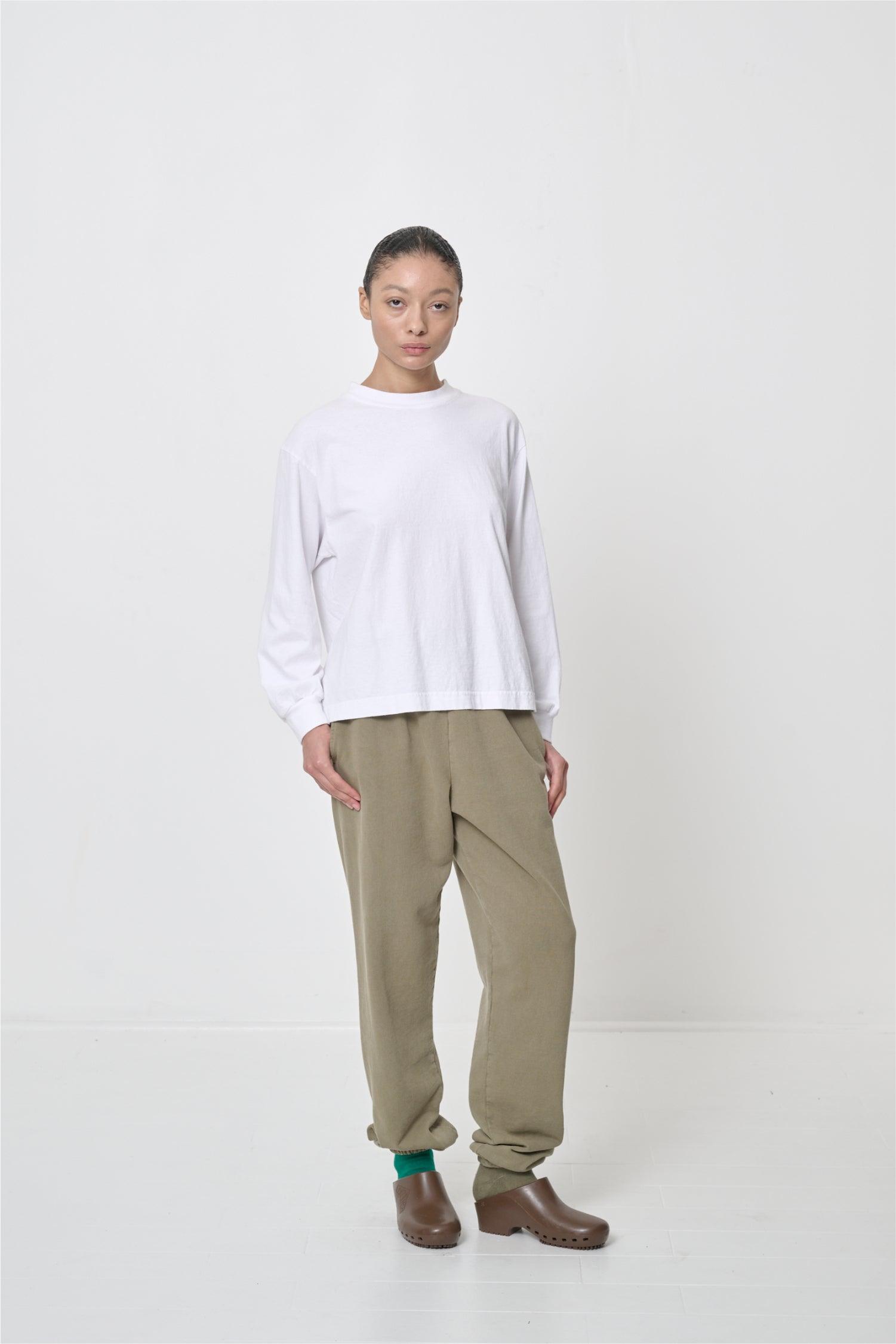 One hand in her pocket and arm bent, showing relaxed drape of the sleeve.