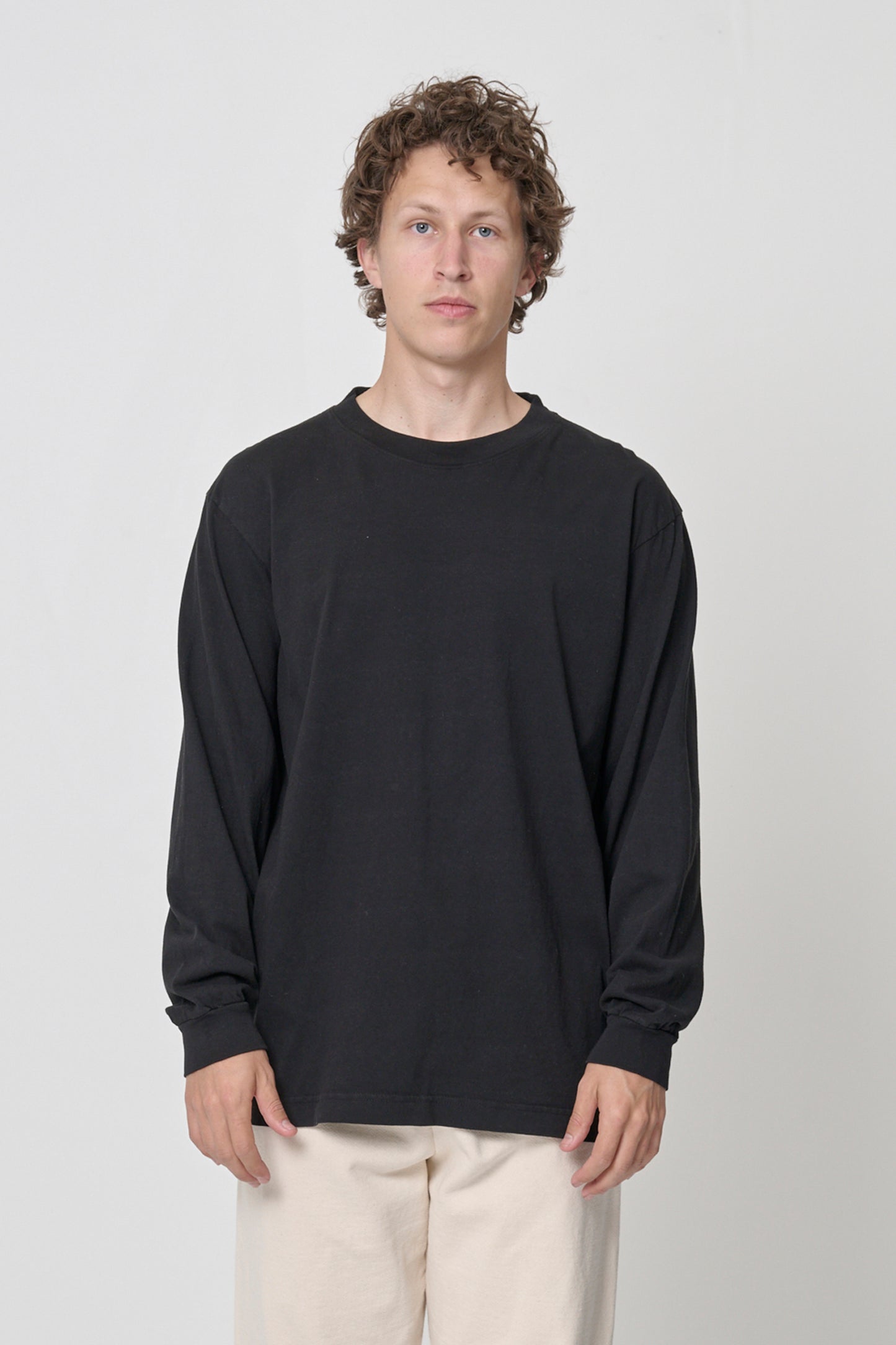 6' man in size M Black Long Sleeve Trash Tee; shirt hem just below the hip, arms at his sides.