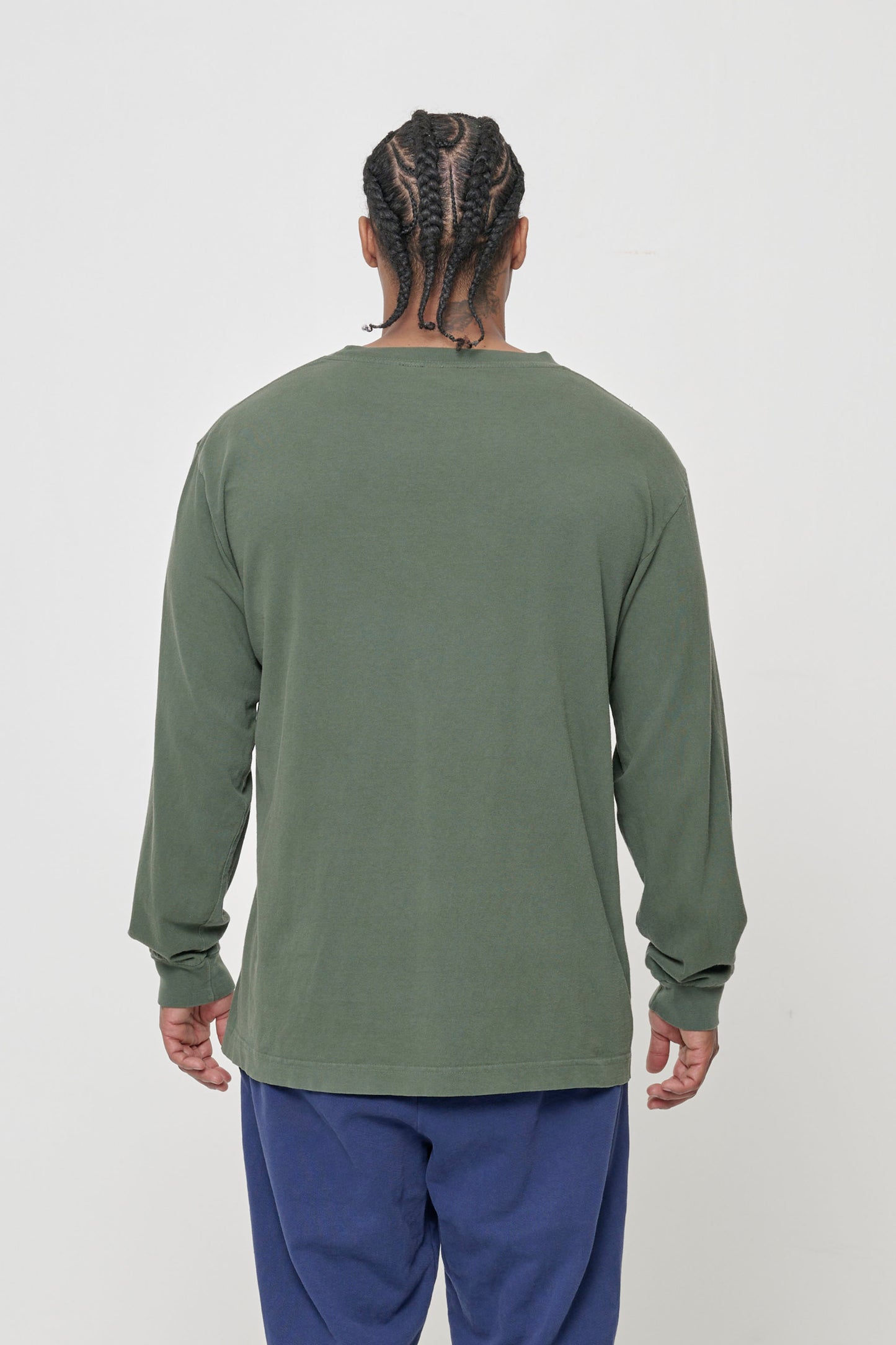 Closeup back view of a person wearing a Pine Long Sleeve Trash Tee, showing fabric drape and relaxed fit throughout.